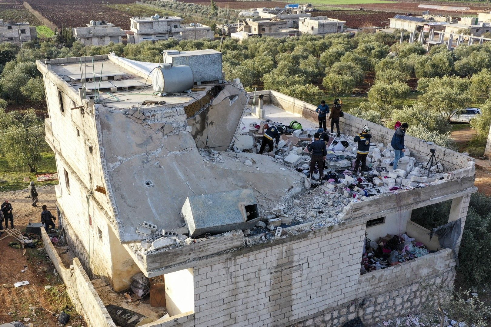 Спасителни екипи инспектират разрушена къща след операция на американските военни в сирийското село Атме, провинция Идлиб, Сирия