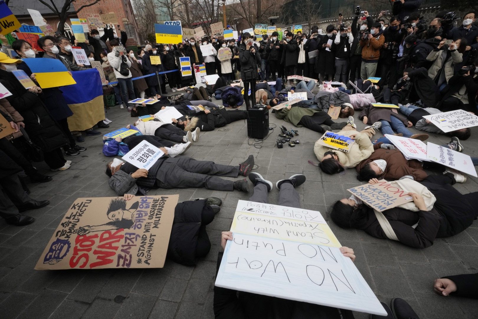 Протестиращи лежат на земята по време на митинг срещу руската инвазия в Украйна, близо до руското посолство в Сеул, Южна Корея, понеделник, 28 февруари 2022 г.