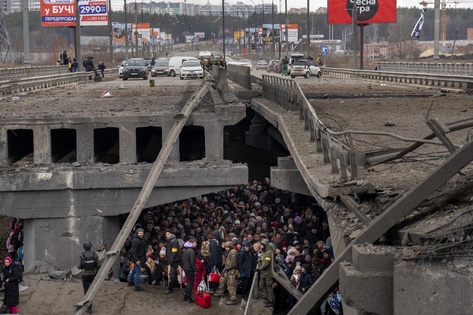 Хора се тълпят под разрушения мост над река Ирпин в едноименни град, недалеч от Киев