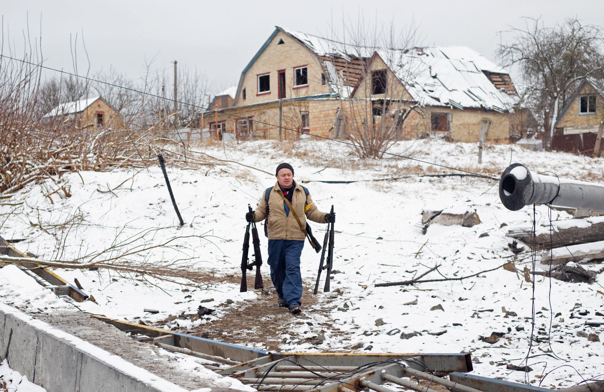 Мъж носи автомати в Ирпин, Украйна 