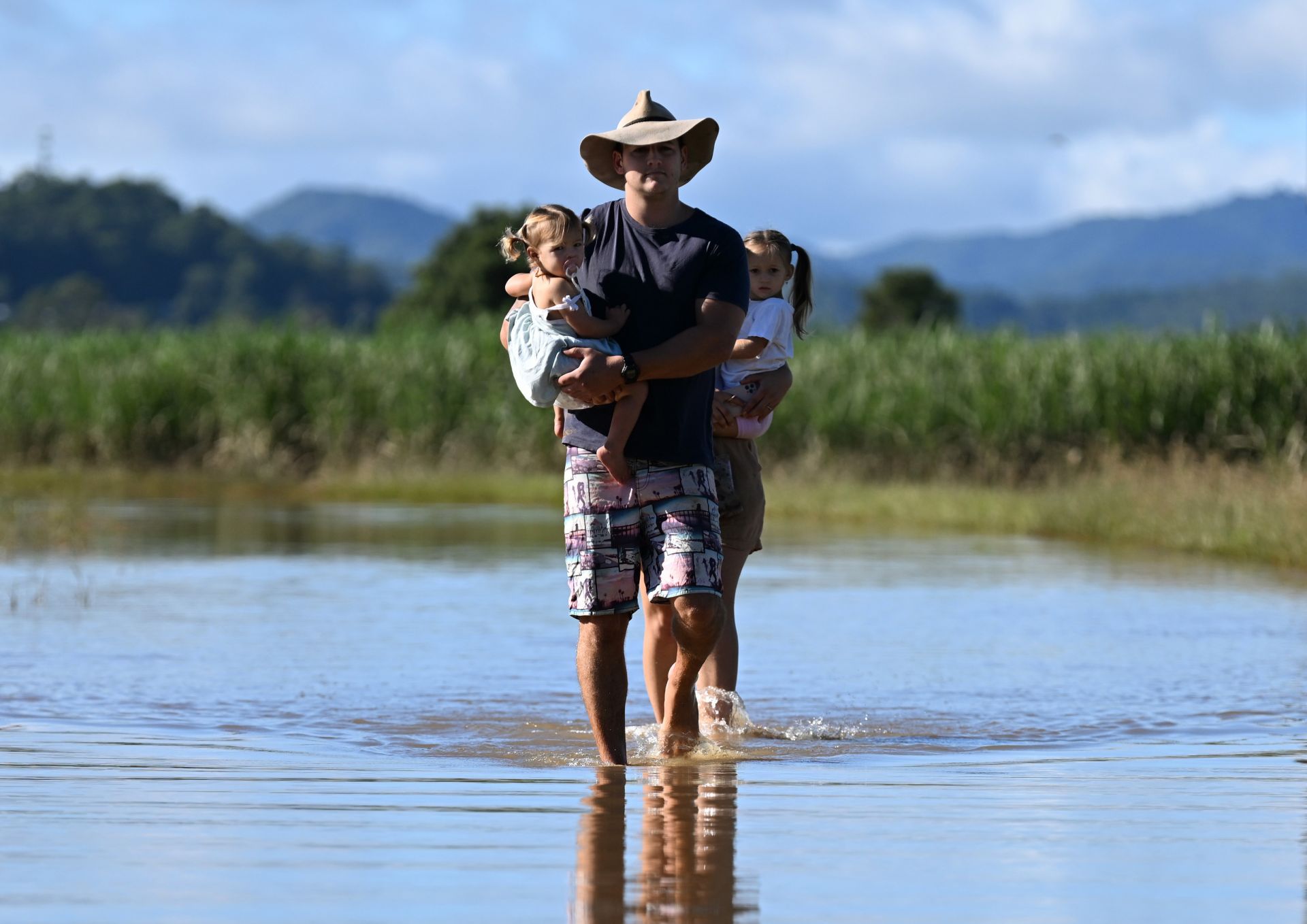 Баща с двете си деца по време на наводненията в Австралия
