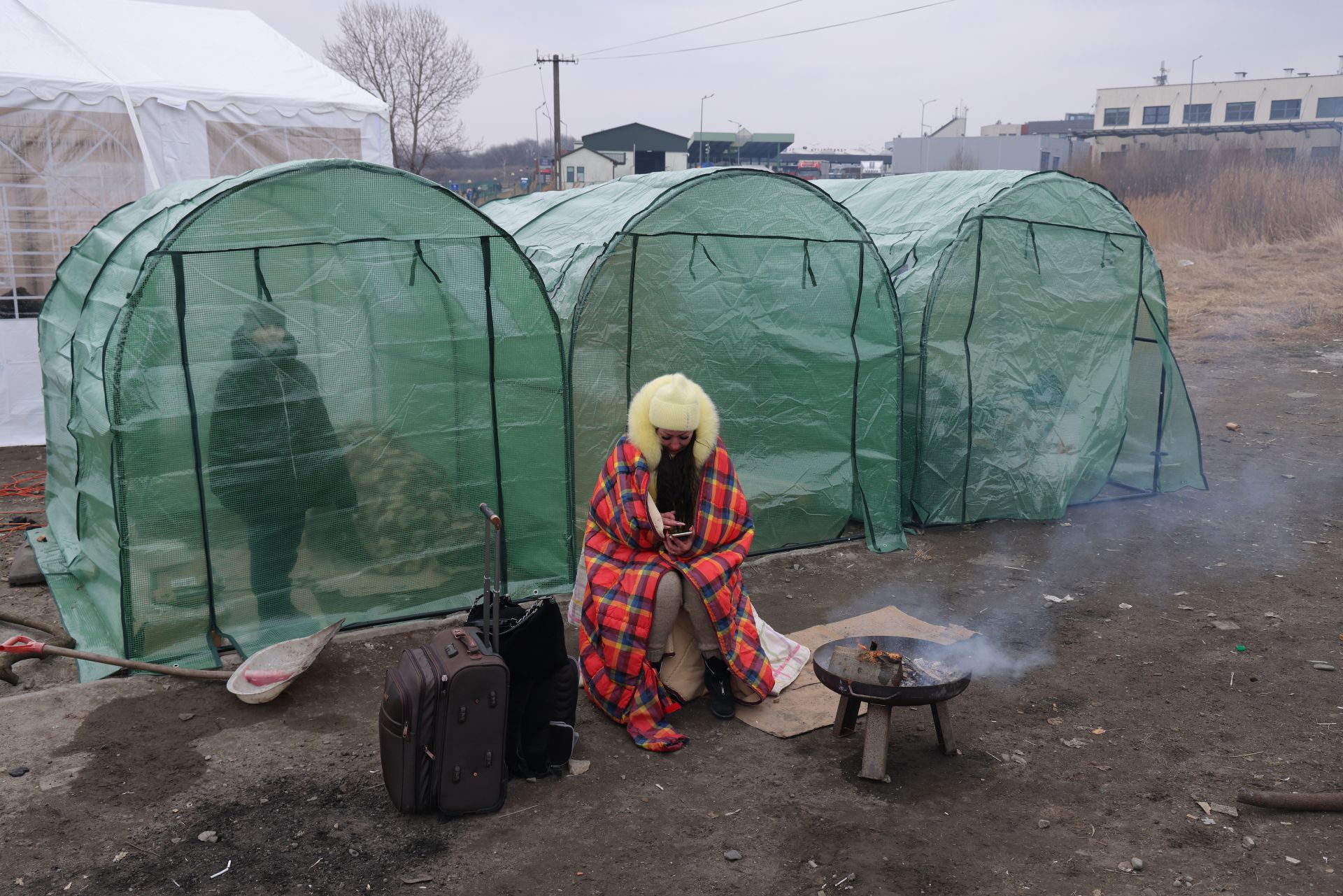 Бегълка от войнта в Украйна се опитва да се стопли на полската граница