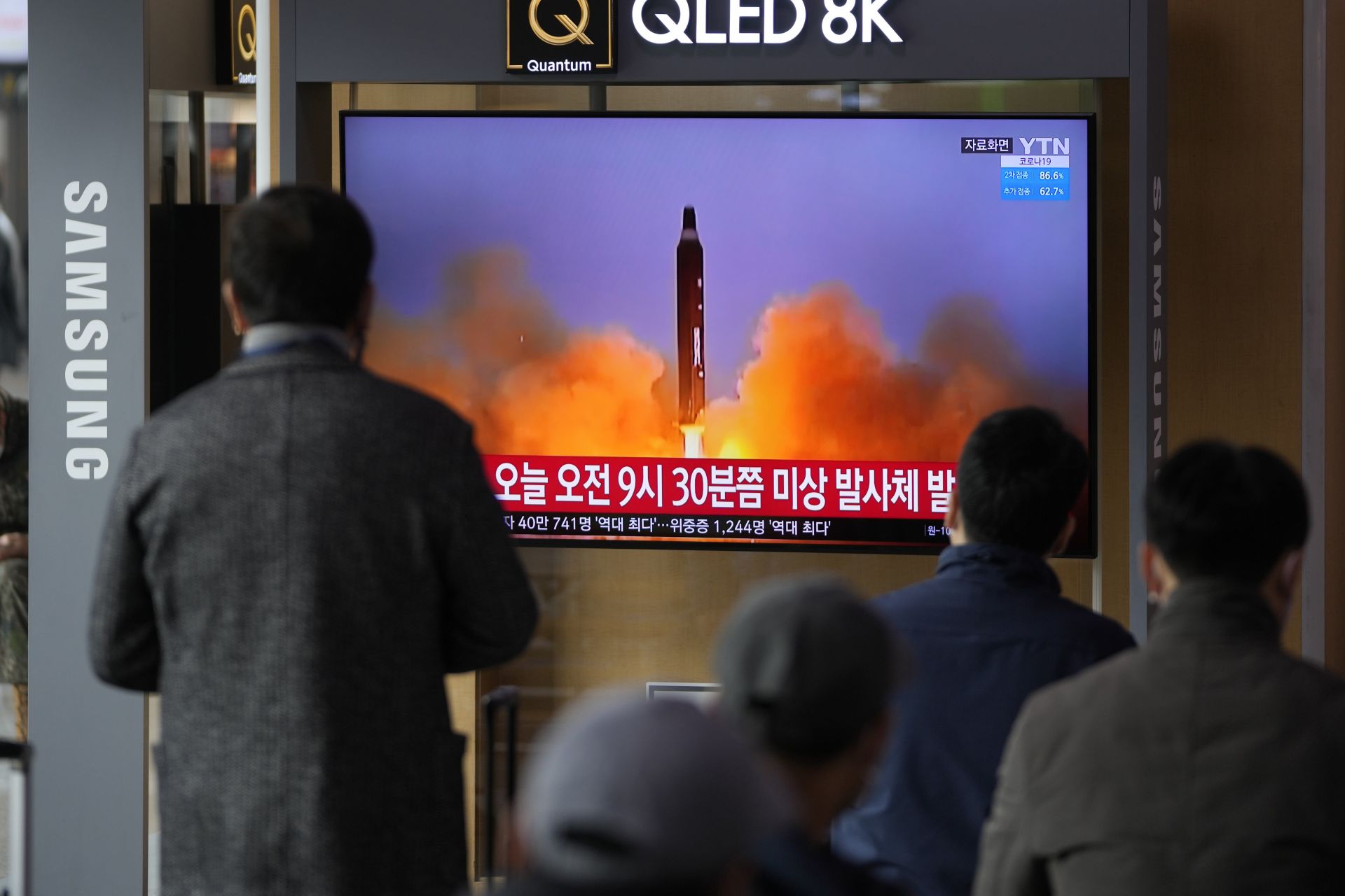 Хората гледат телевизионен екран, показващ новинарска програма, съобщаваща за ракетата на Северна Корея с кадри, на гара в Сеул, Южна Корея, сряда, 16 март 2022 г.