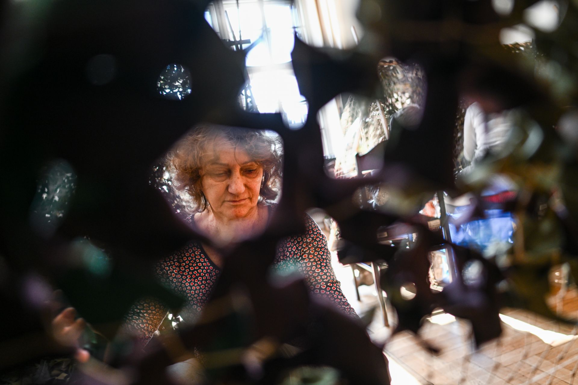 Жена, избягала от войната в Украйна, тъче камуфлажна мрежа в обществената библиотека в Краков, Полша