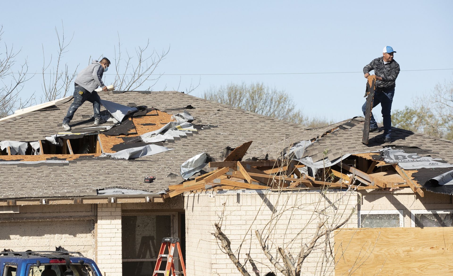 Мъже работят върху повредения покрив на къща в Раунд Рок, Тексас