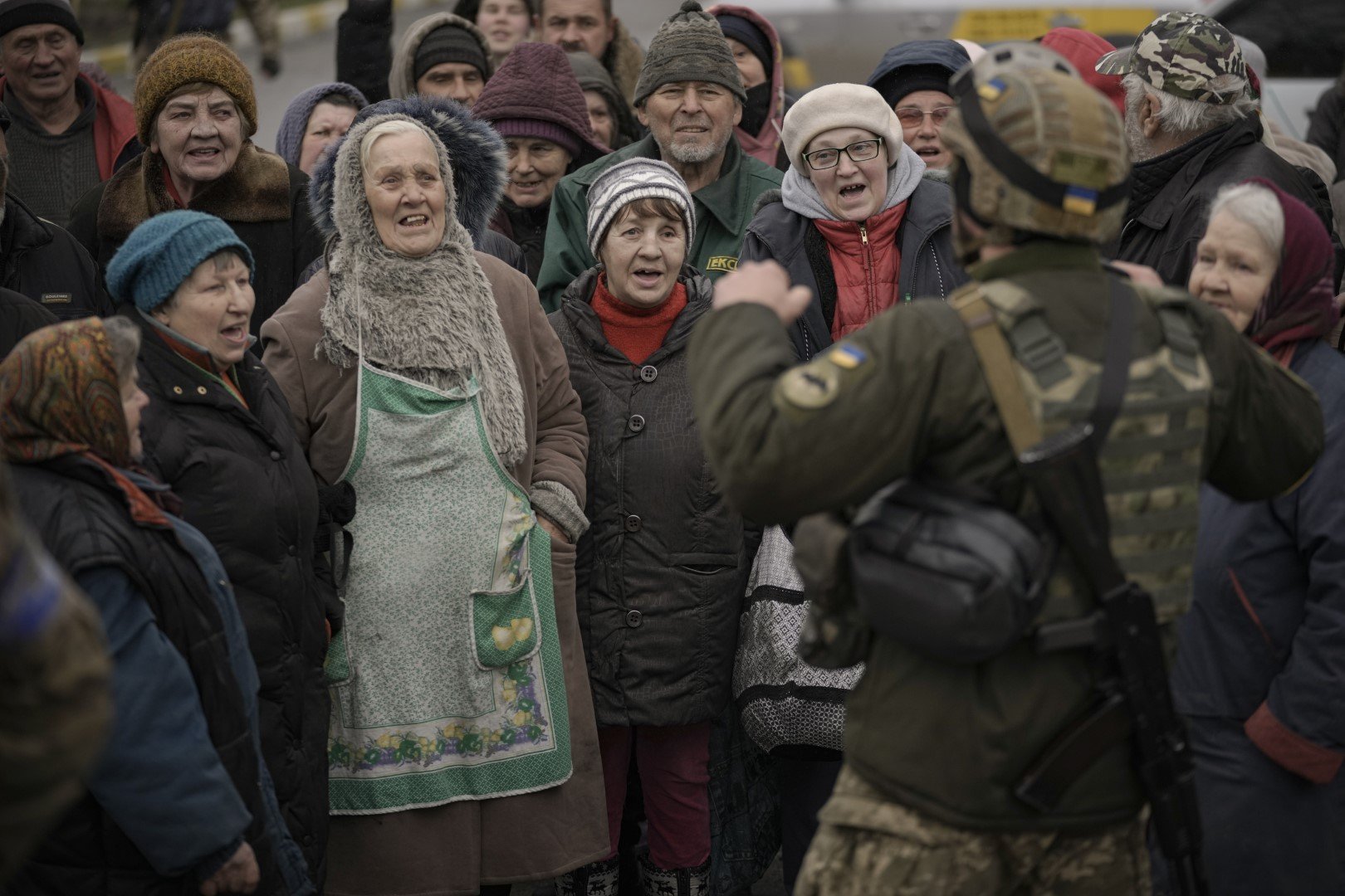 Цивилни пеят заедно с украински военнослужещ в предградието на Киев Буча в събота, 2 април 2022 г.