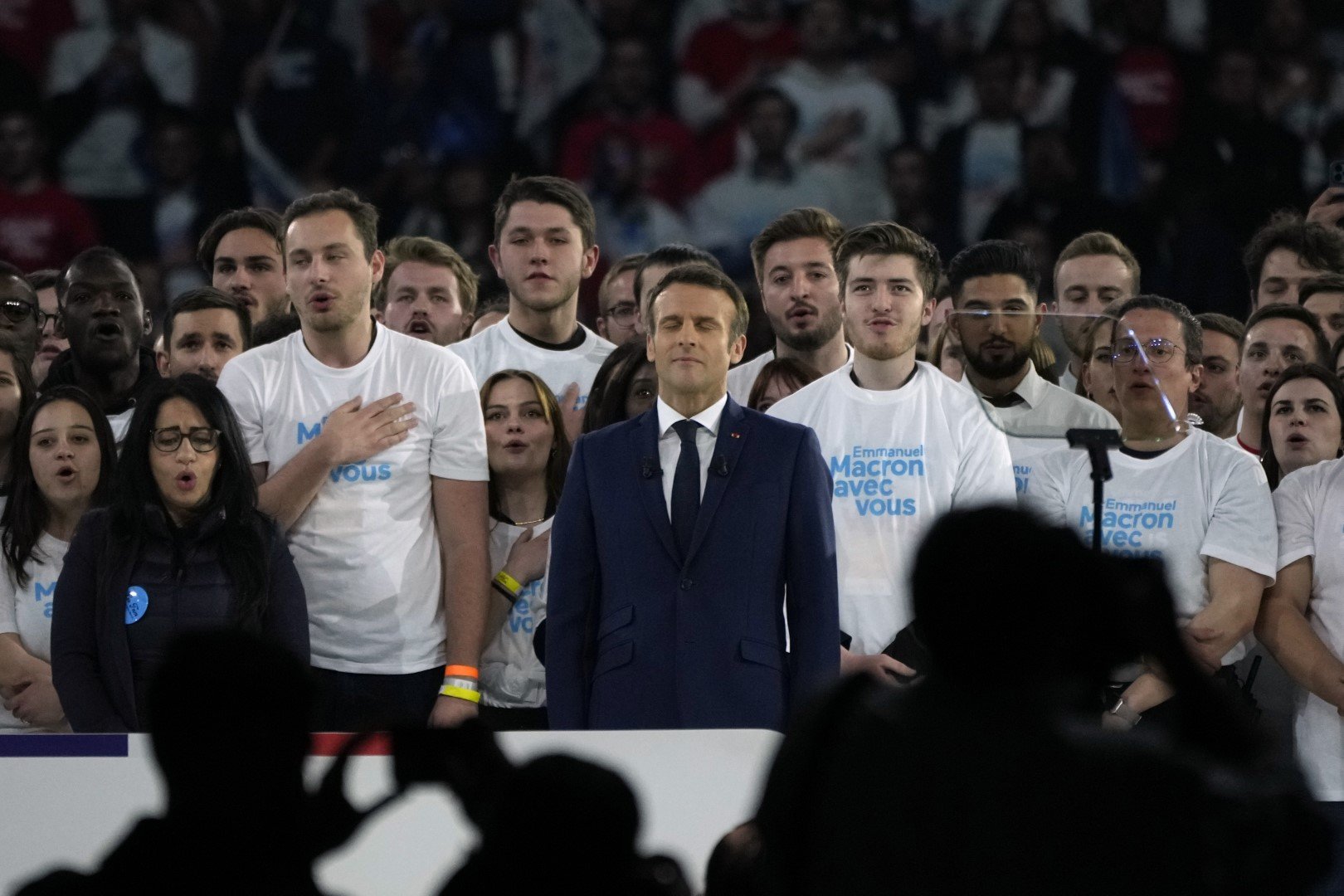 Френският президент и кандидат за втори мандат Еманюел Макрон пее заедно със свои привърженици националния химн по време на предизборна проява в Париж, събота, 2 април 2022 г.