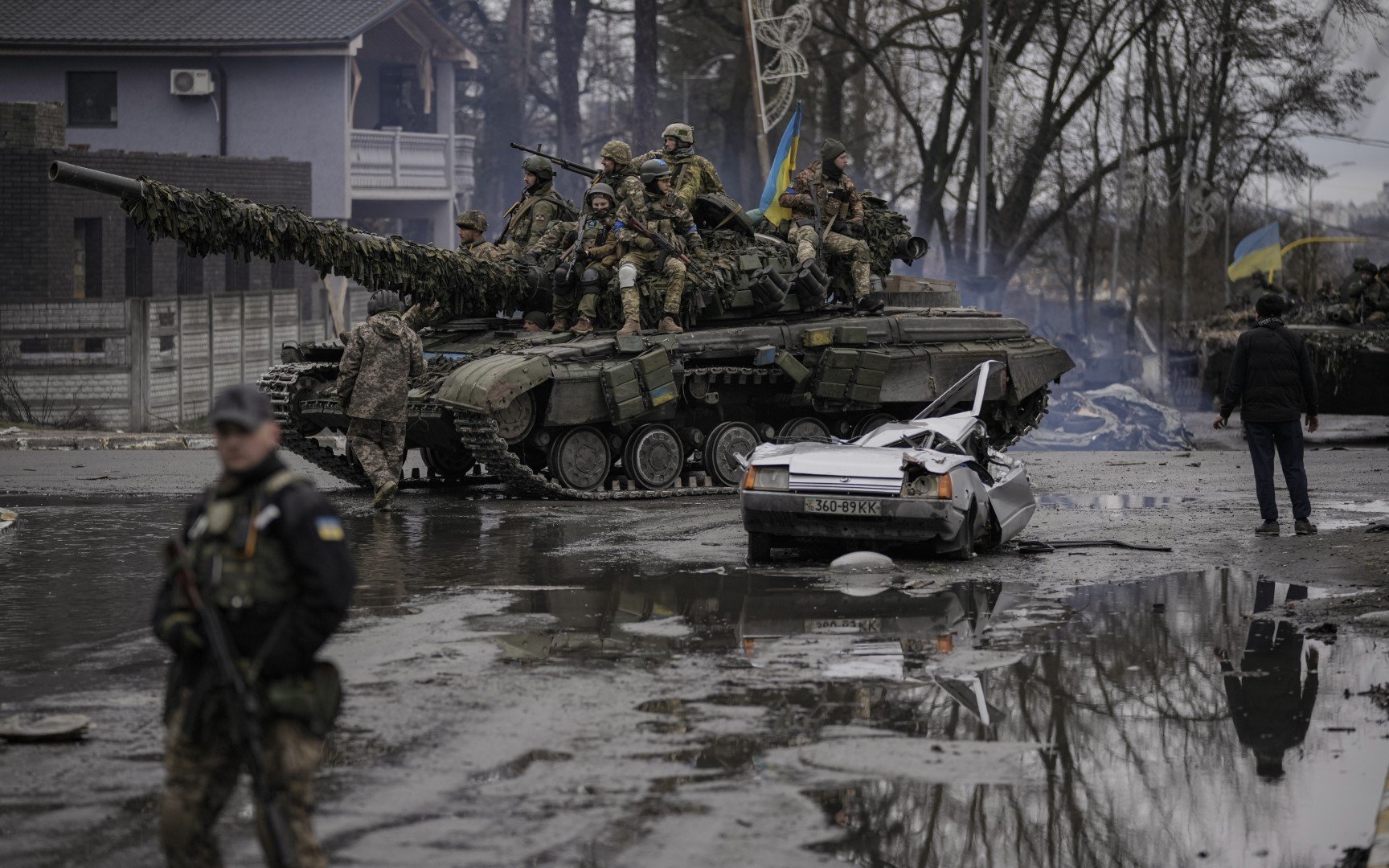Унищожена кола, зад нея танк с украински войници край Киев на 2 април