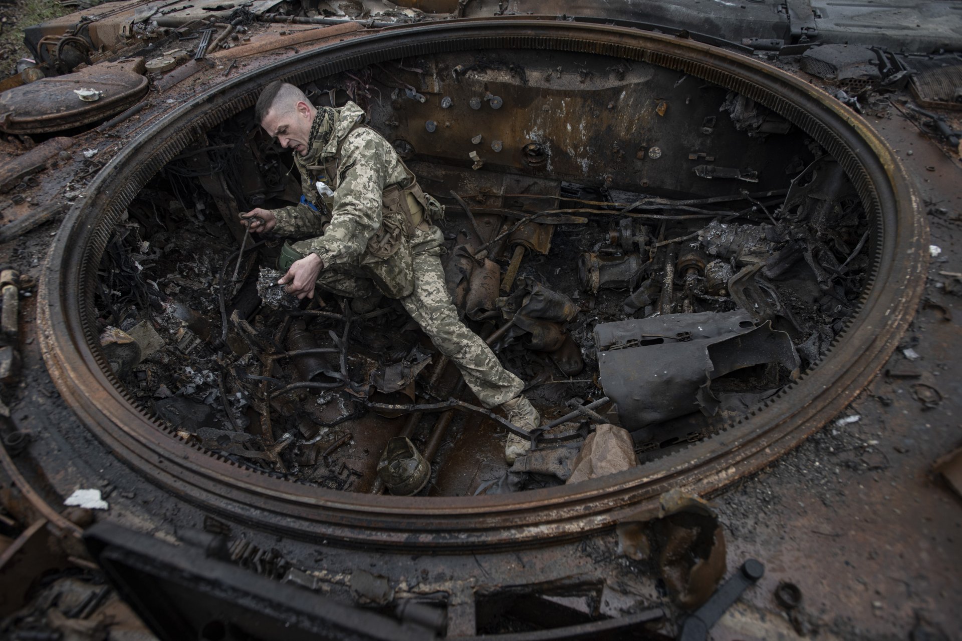 Украински войник инспеткира опожарен руски танк край Киев