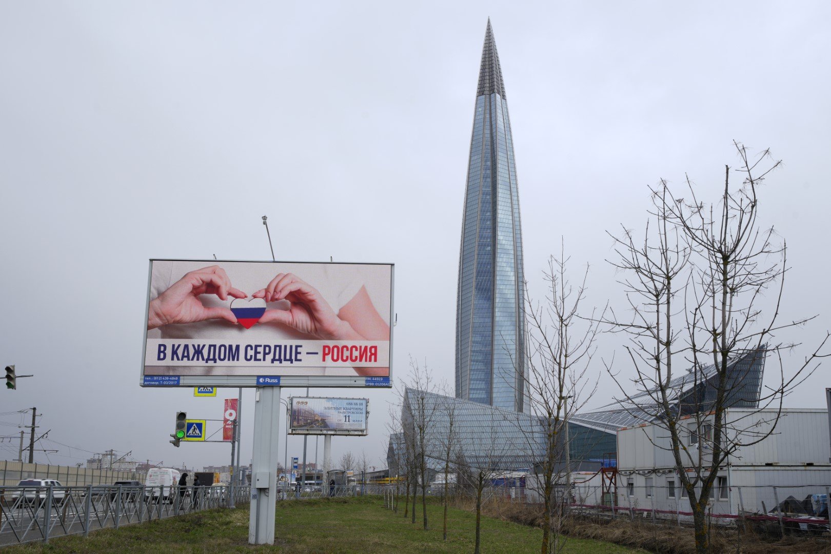 Изглед към бизнес кулата Лакта Център на Газпром в Санкт Петербург, сряда, 27 април 2022 г., напреден план е билборд с надпис „Русия във всяко сърце“