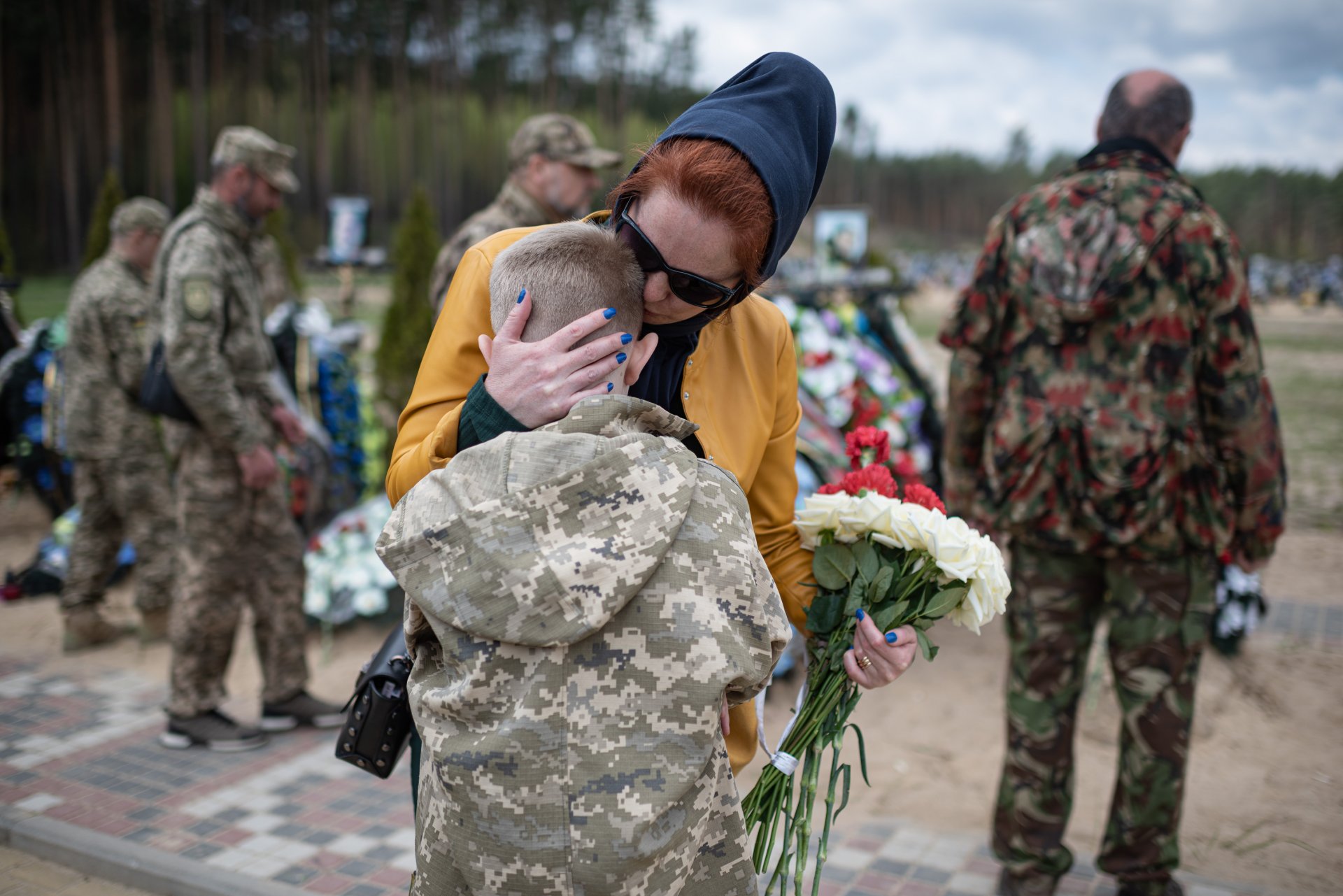 Дете с майка си посещава гроба на баща си - Игор Кротки, загинал в Ирпин, Украйна
