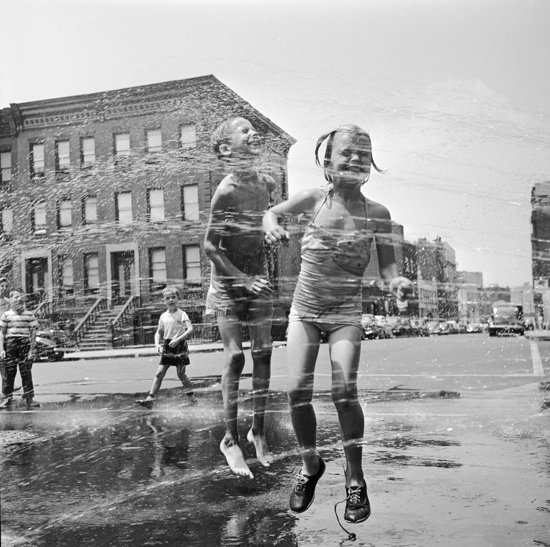 Две деца се къпят на улица в Ню Йорк. 