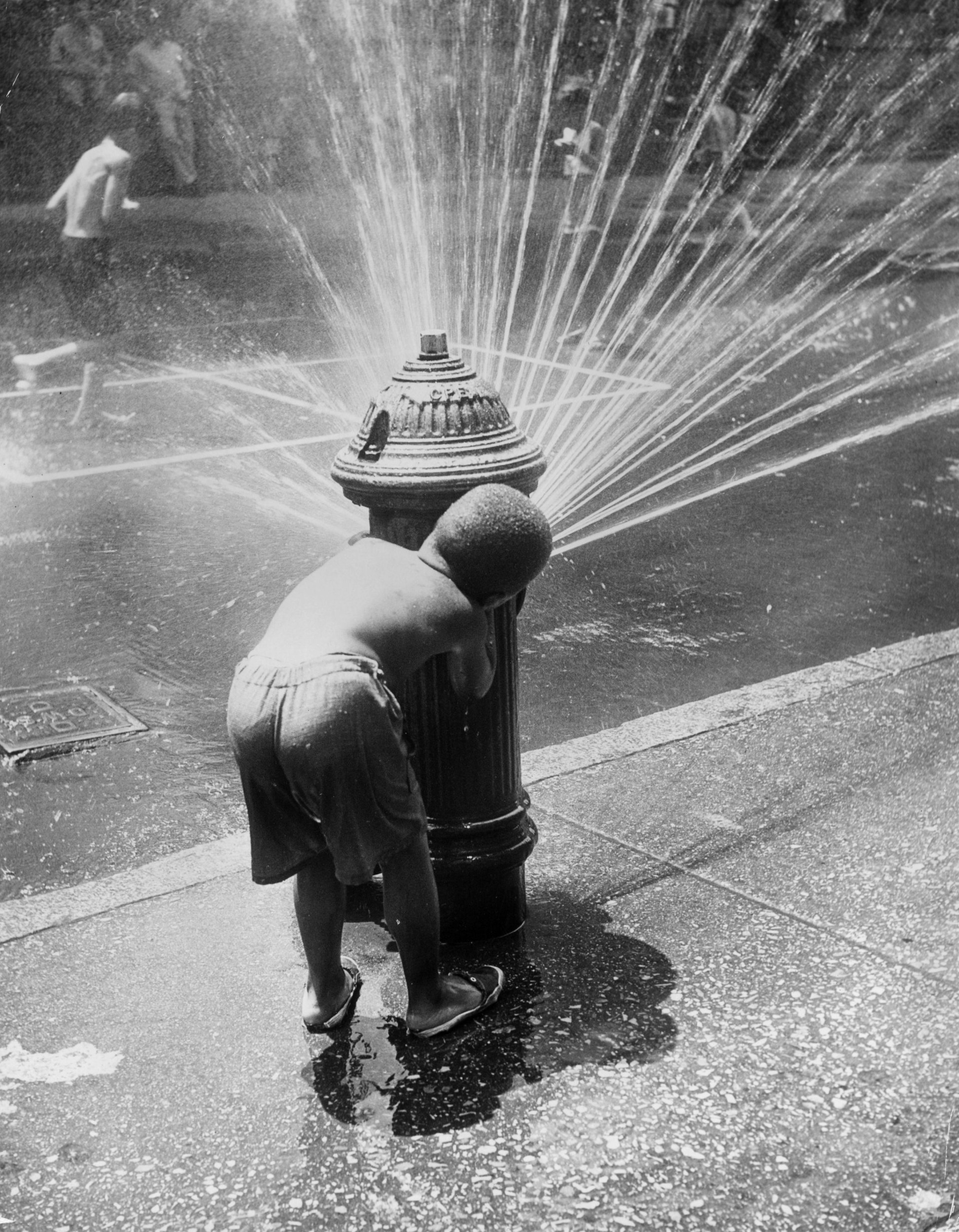 Oколо 1945 г.: Деца в Ню Йорк се разхлаждат под пръските на пожарен хидрант по време на гореща вълна.