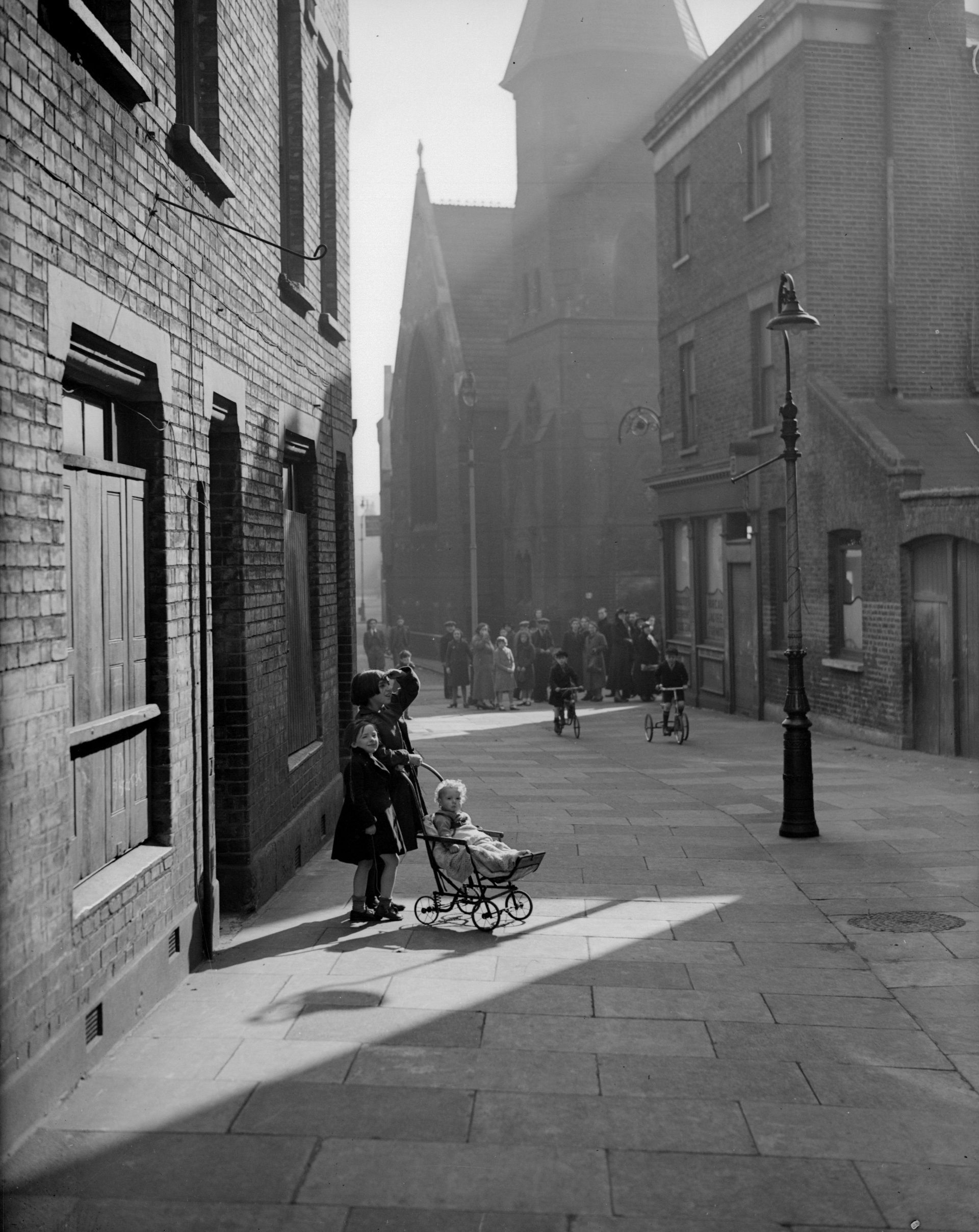 Около 1938 г.: Деца на слънце, близо до улица Горна Темза в лондонското Сити. 