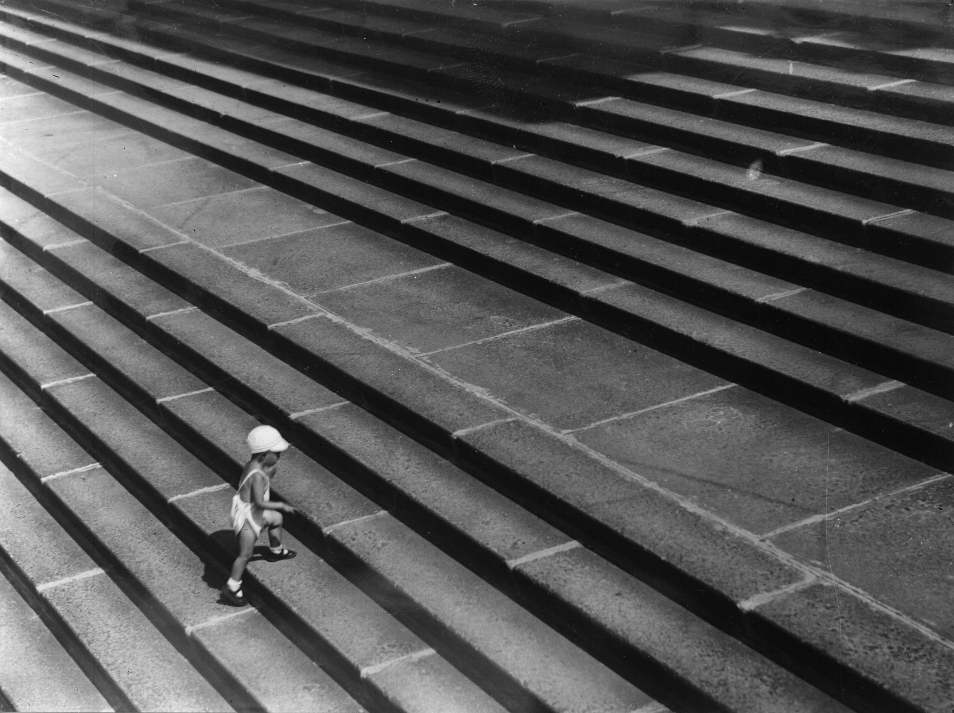 Oколо 1935 г.: Малко момче със слънчева шапка се изкачва по широки стъпала. (Снимка от General Photographic Agency/Getty Images)