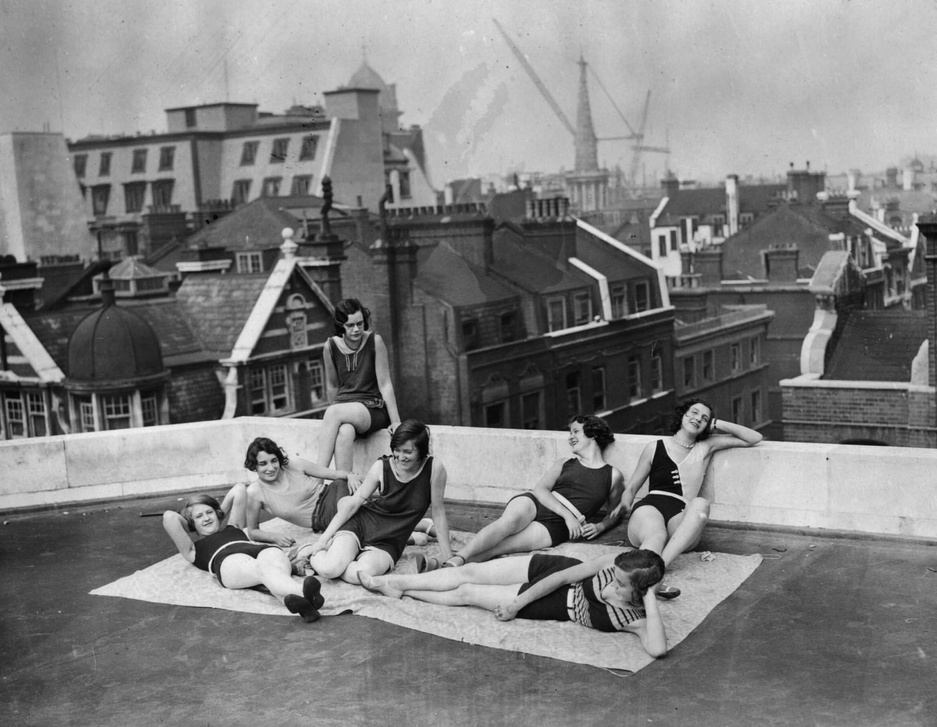 30 август 1930 г.: Шивачки правят слънчеви бани по време на сутрешната си почивка на покрива на Great Portland Street, Лондон. (Снимка от Topical Press Agency/Getty Images)