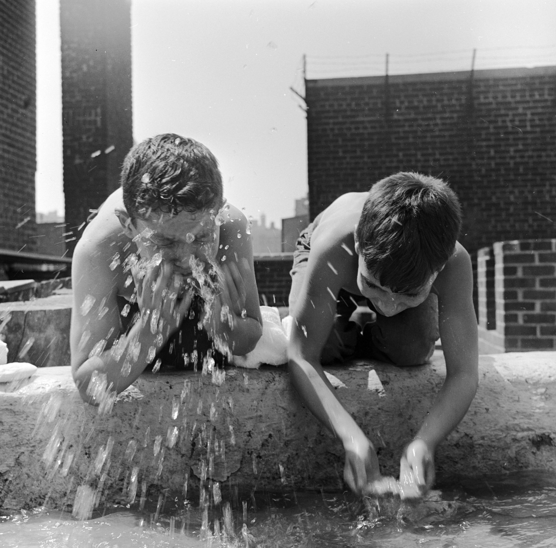 Oколо 1955 г.: Двама къмпингуващи от Madison Square Boys Club си мият лицата преди закуска в летния лагер на покрива в Ню Йорк. 