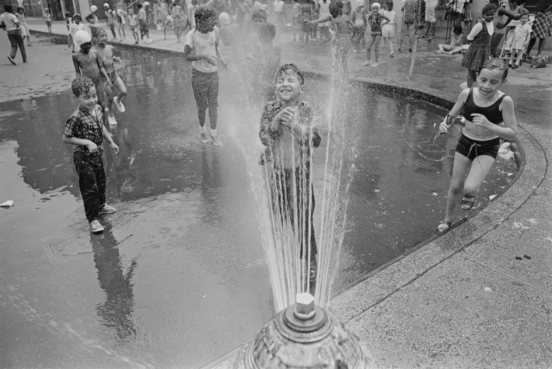  Деца, които се охлаждат по струята на  пожарен хидрант в Харлем, Ню Йорк, август 1966 г. (Снимка от Harry Benson/Express/Hulton Archive/Getty Images)