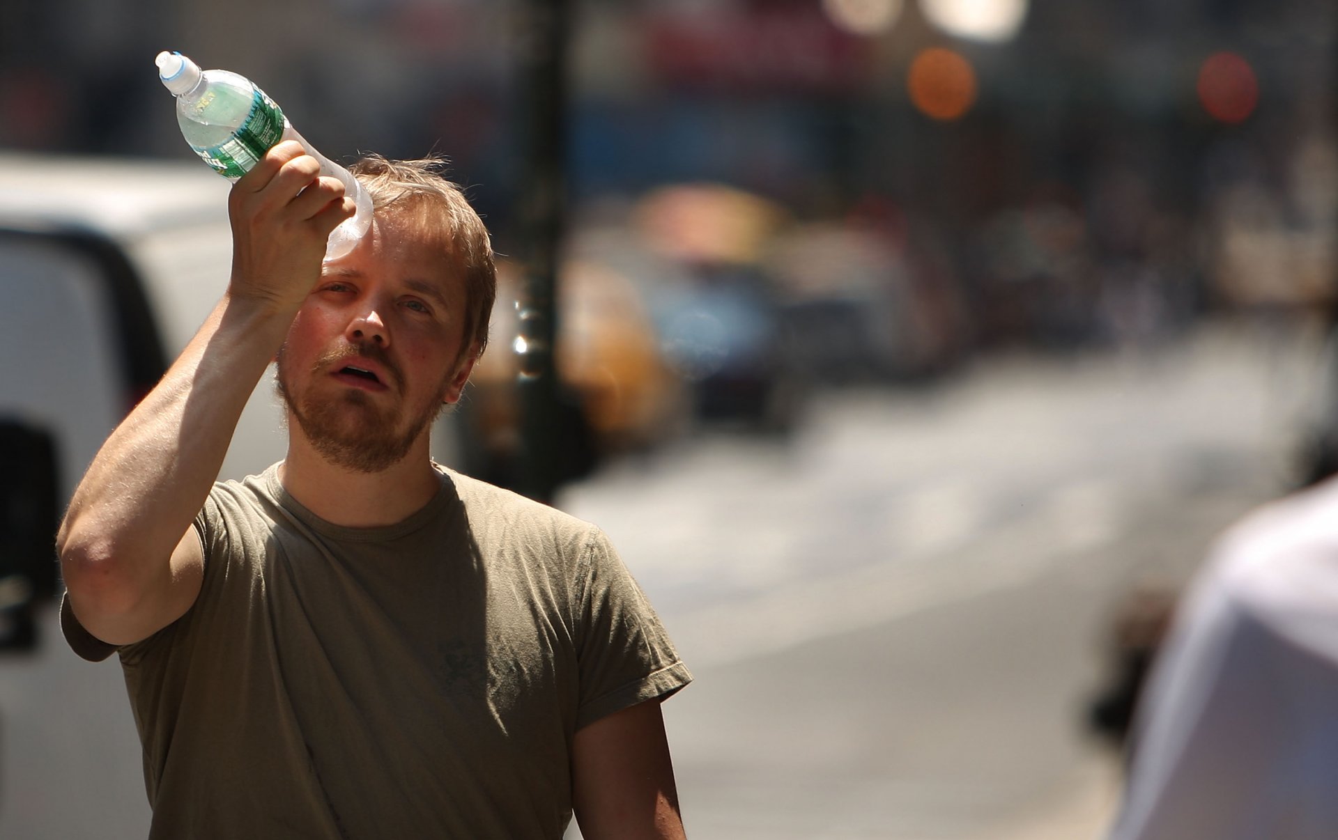НЮ ЙОРК - 9 ЮНИ: Мъж се опитва да се охлади с бутилка вода по време на първата гореща вълна за годината на 9 юни 2008 г. в Ню Йорк. Според Националната метеорологична служба температурите са близо 100  по Фаренхайт градуса в района на метрото в Ню Йорк