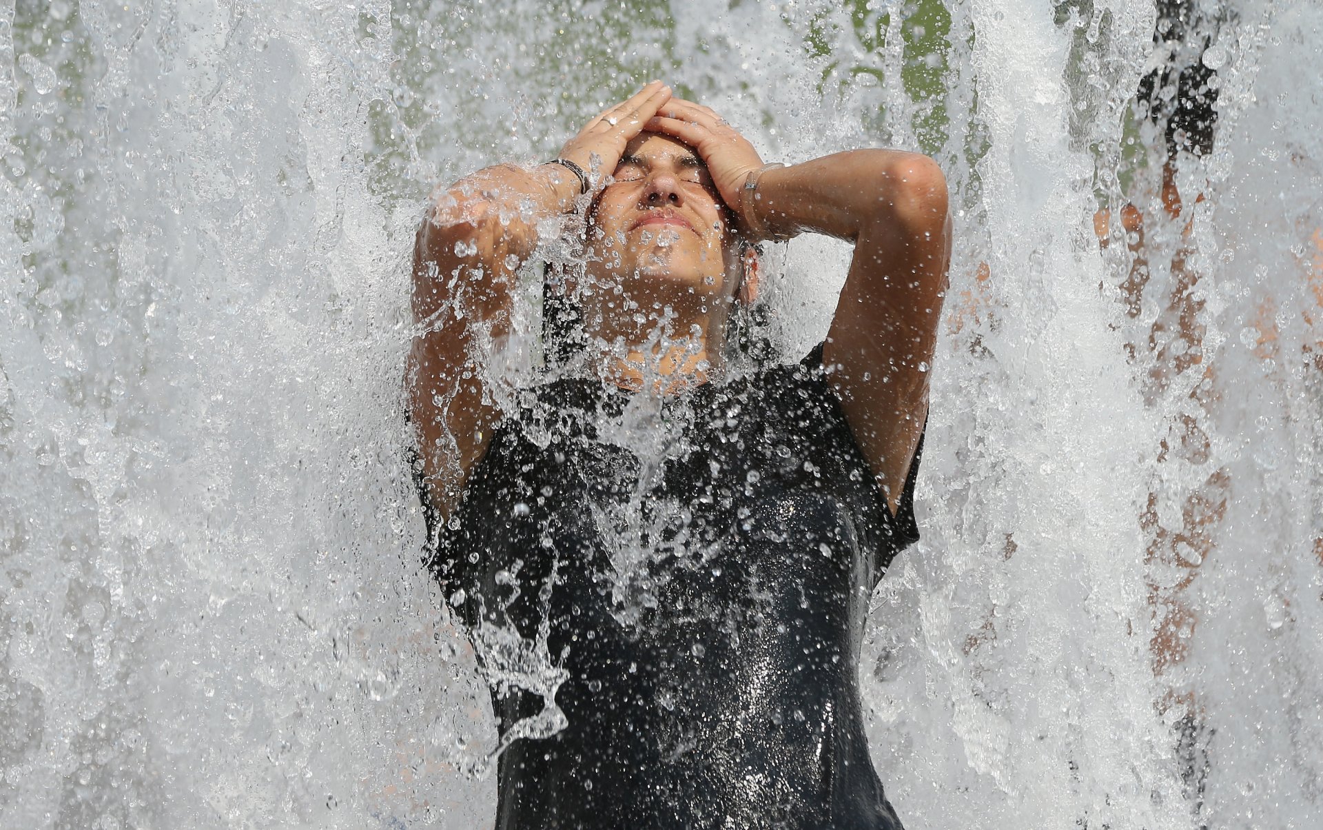  Млада жена от Бразилия се разхлажда във фонтан в горещ летен ден в центъра на града на 20 юни 2013 г. в Берлин, Германия. Централна Европа е в плен на гореща вълна, при която температурите в някои региони достигнаха до 38 градуса по Целзий.