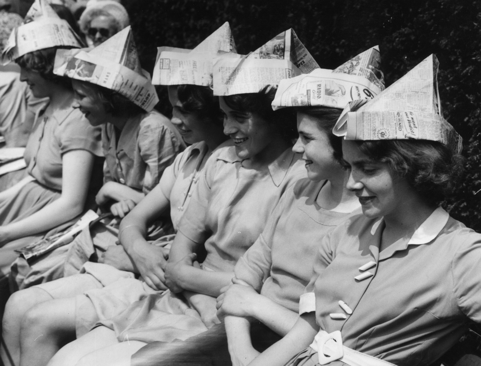 25 юни 1953 г.: Ученички от Gravesend Grammar School с шапки от вестници, за да се предпазят от слънцето, докато гледат Уимбълдън по време на гореща вълна. (Снимка от Уилям Вандерсън/Fox Photos/Getty Images)