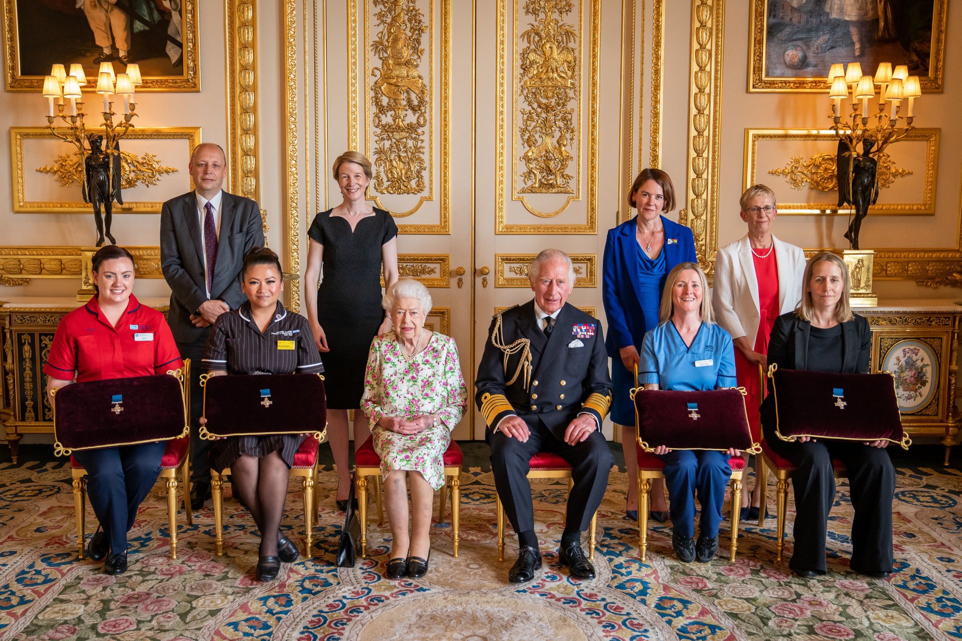  Кралица Елизабет II с представители на Националната здравна служба г-н Питър Мей, постоянен секретар в Министерството на здравеопазването и главен изпълнителен директор на здравеопазването и социалните грижи, и сестра Джоана Хог, Спешна помощ в болница Royal Victoria Отдел, по време на аудиенция в замъка Уиндзор на 12 юли 2022 г. 