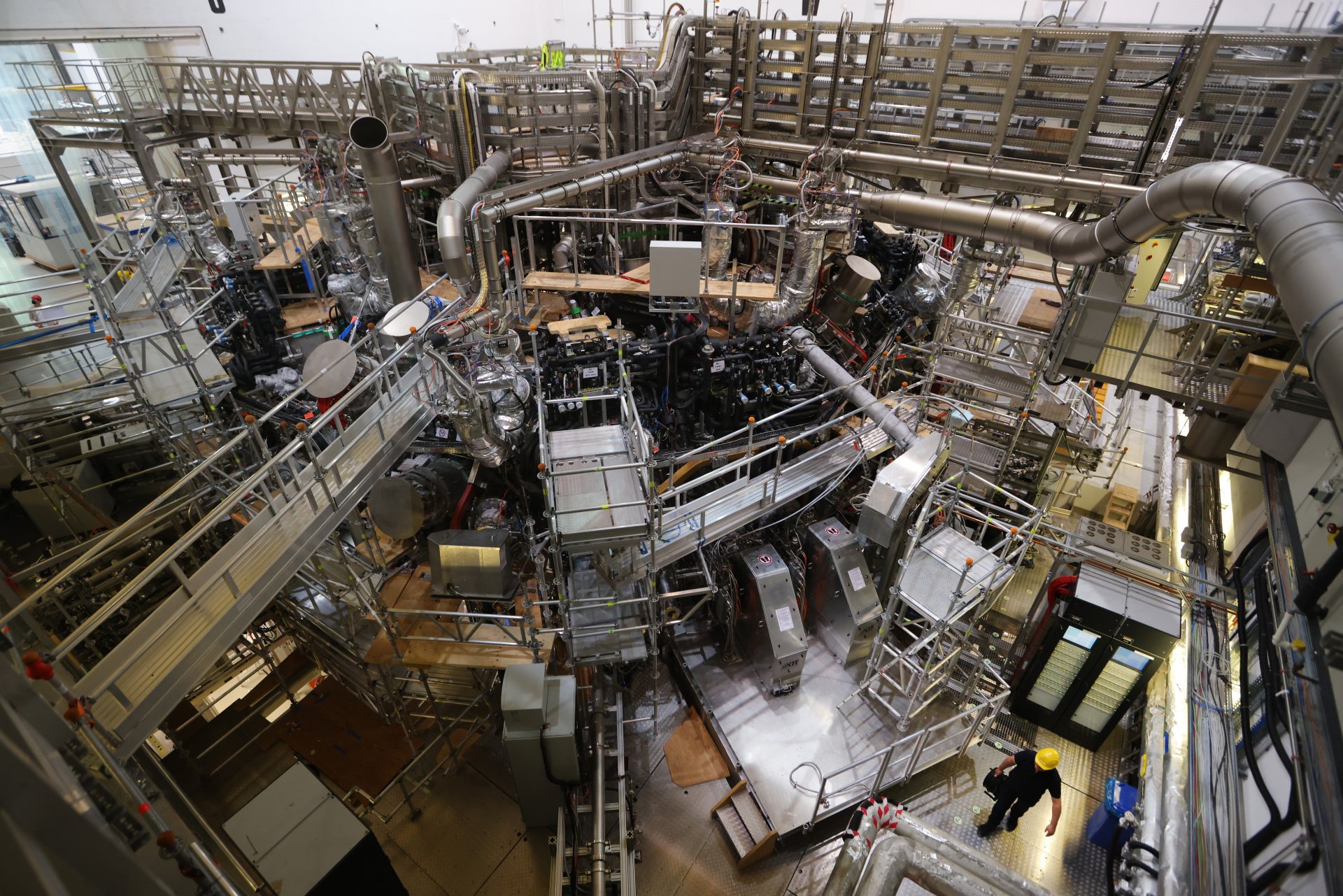 Работник под стеларатора Wendelstein 7-X в деня на тържеството, с което се отбеляза готовността му за нова фаза от експерименти, които се провеждат под егидата на  Института за физика на плазмата Макс Планк (IPP). 