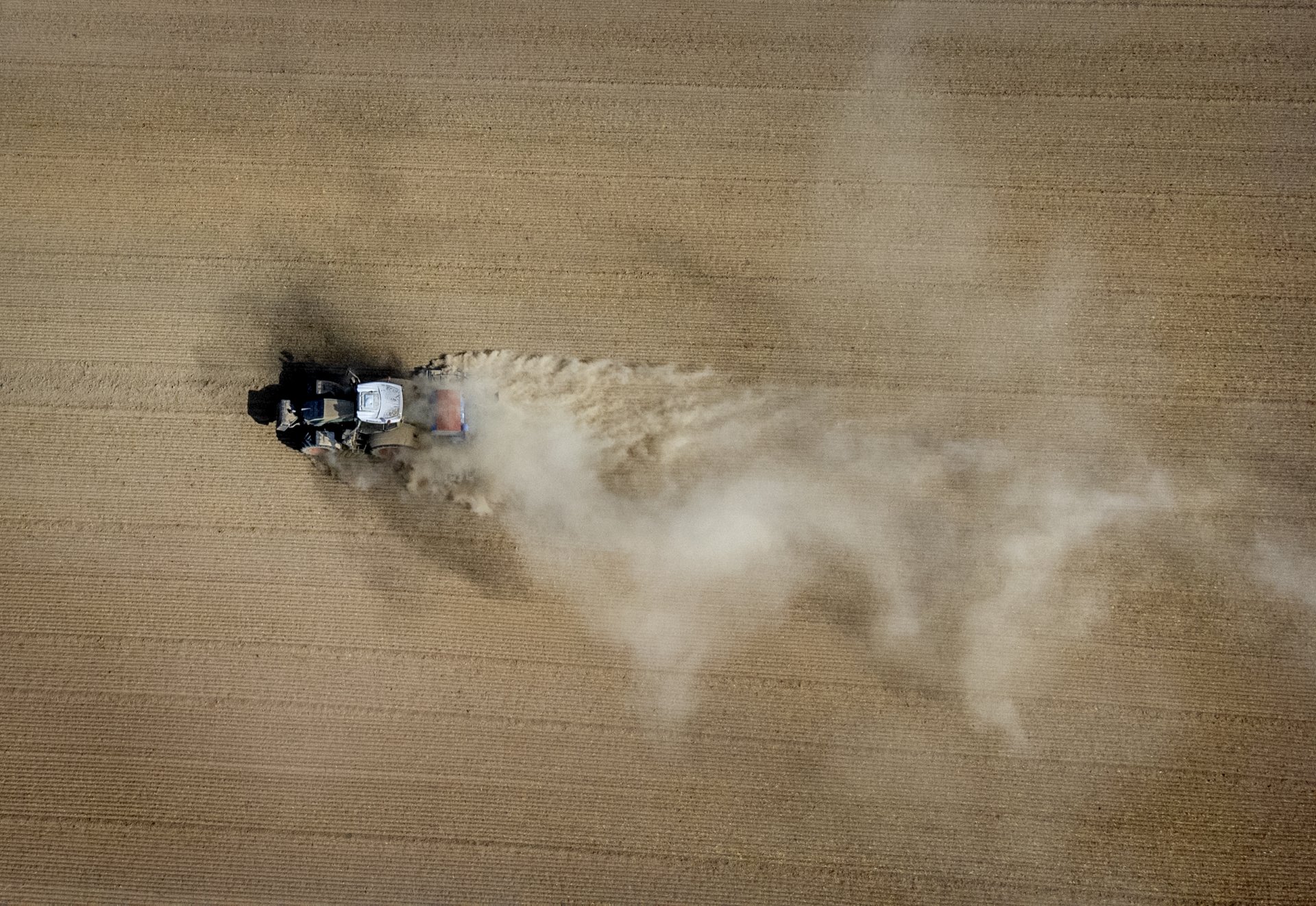 Фермер вдига прах, докато работи с трактора си на поле в Ню Анспах близо до Франкфурт, Германия, сряда, 24 август 2022 г.