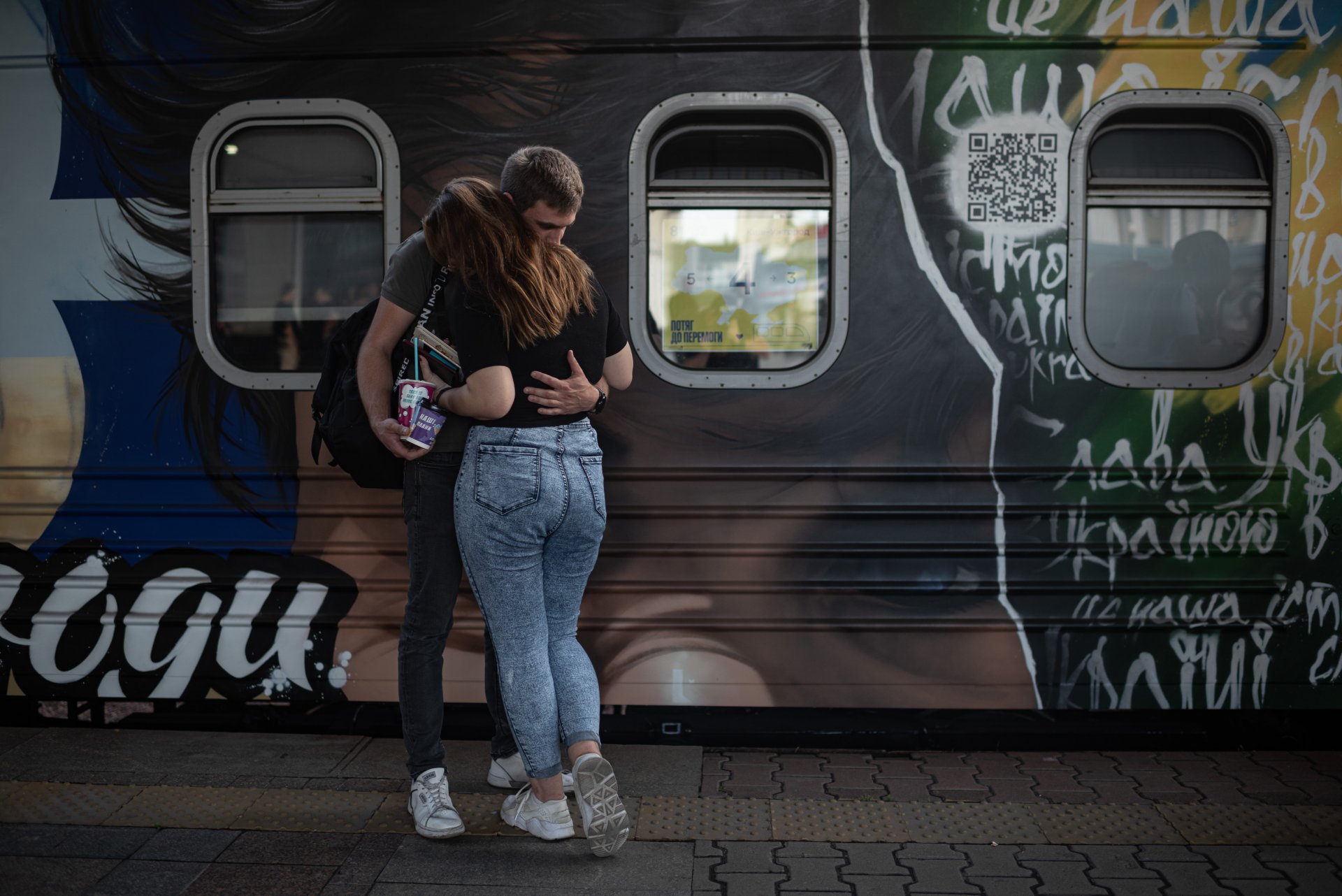 Двойка се прегръща до един от вагоните на "Влака към победата" в Киев, Украйна.