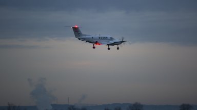 Пилот на малък двумоторен самолет прелитащ на град в щата