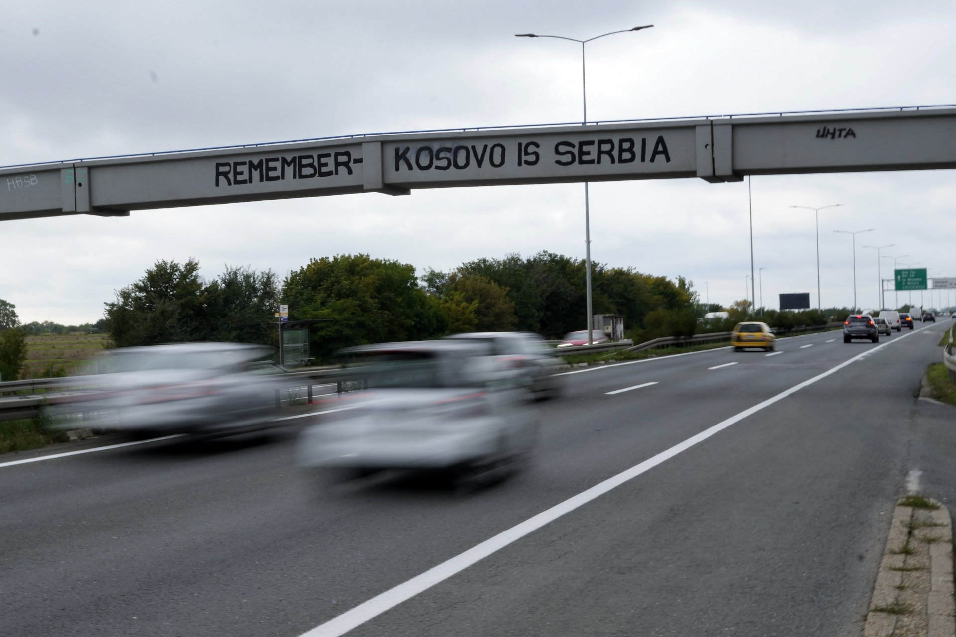 Коли минават по магистрала под пешеходен мост с графити върху него с надпис „Запомнете – Косово е Сърбия“ в Белград, Сърбия, сряда, 21 септември 2022 г.
