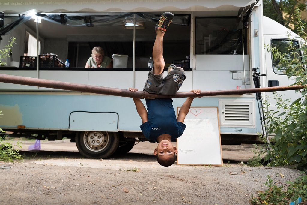 Момче играе пред камиончето за храна на "Доброволците на Св. Георги", където три пъти седмично се приготвя и раздава топла храна на хора в нужда. София, 3 юли 2022
