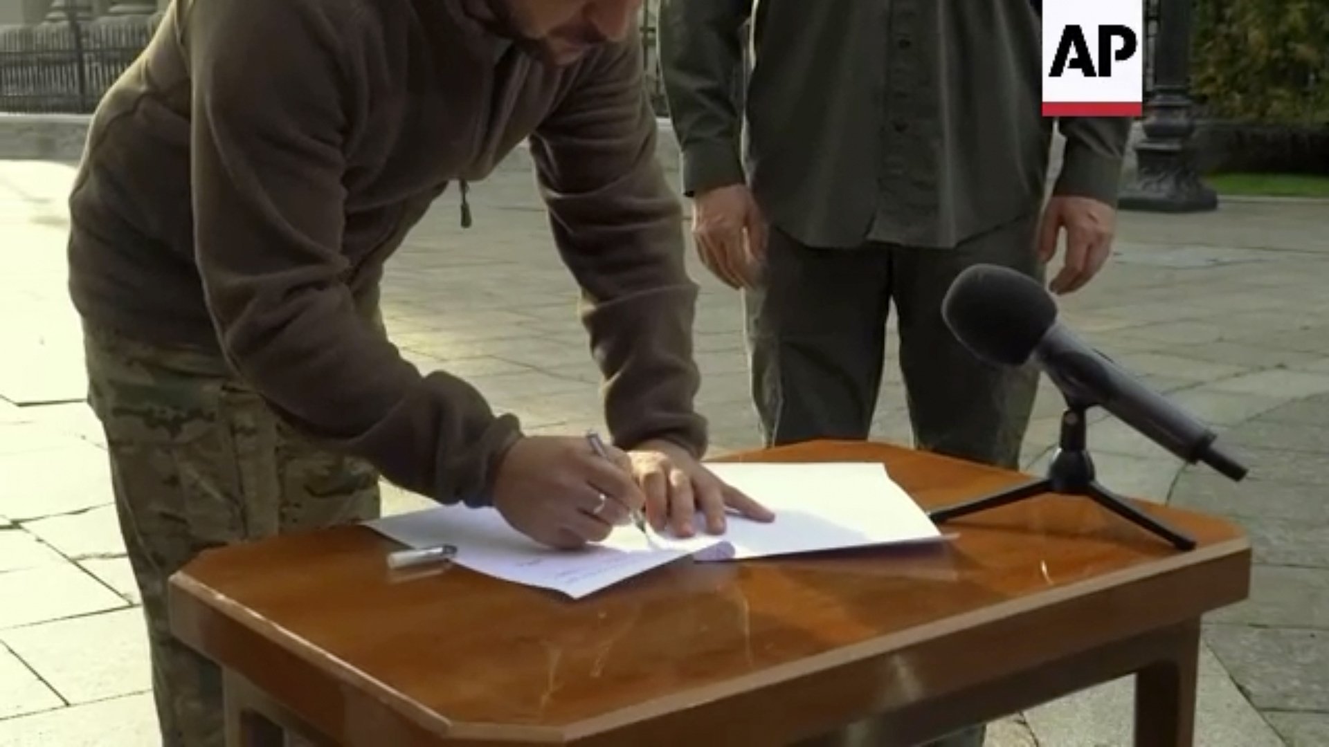 Снимка, направена от видео, показва как украинският президент Володимир Зеленски подписва заявление за „ускорено присъединяване към НАТО“ в Киев, Украйна, петък, 30 септември 2022 г.