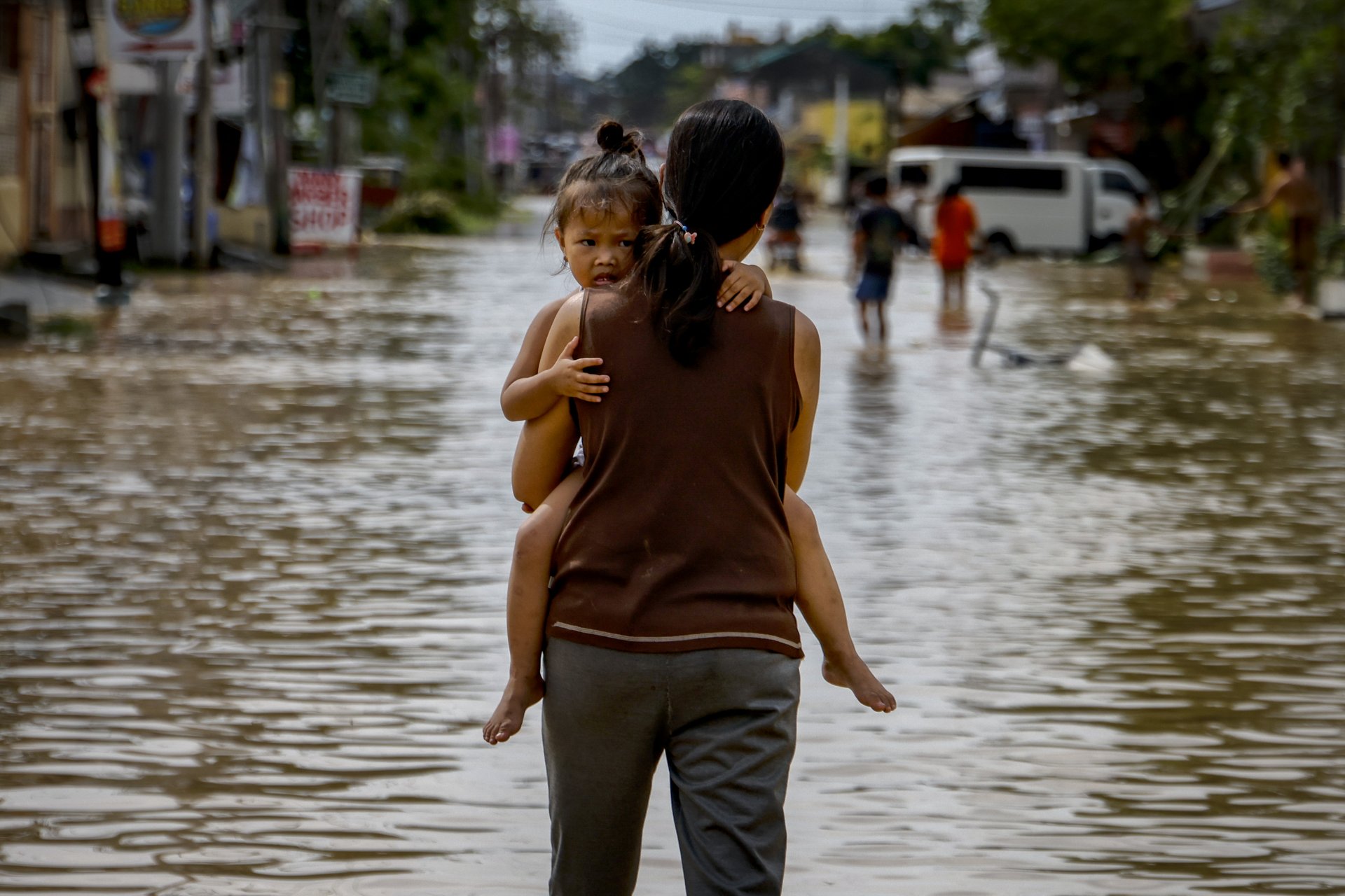 Майка и дете насред наводненията, причинени от супер тайфуна Нору на 26 септември 2022 г. в Сан Мигел, провинция Булакан, Филипините. 