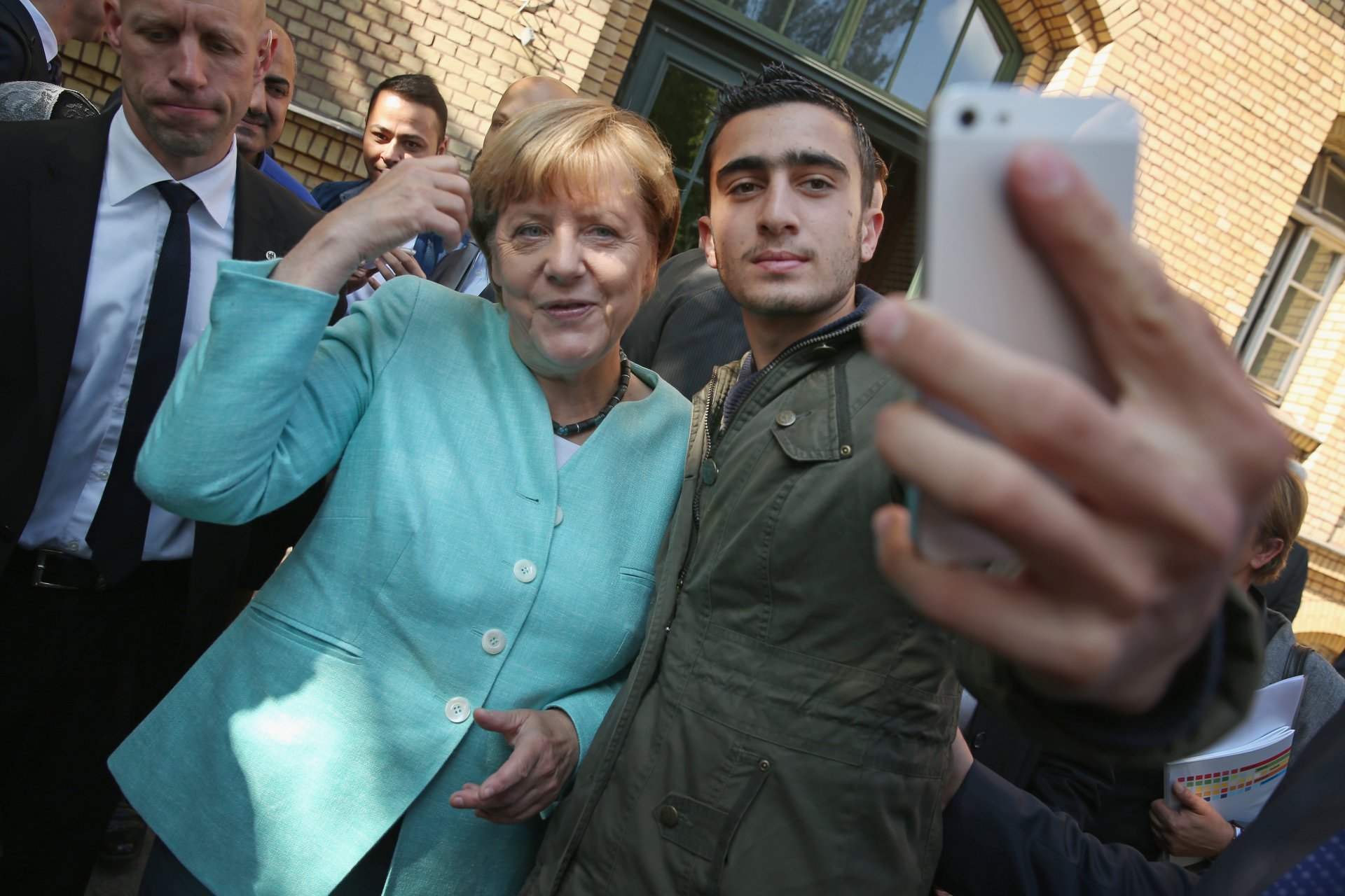 Ангела Меркел позира за селфи с бежанец от Сирия в легер за мигранти на 10 септември 2015 г. в Берлин