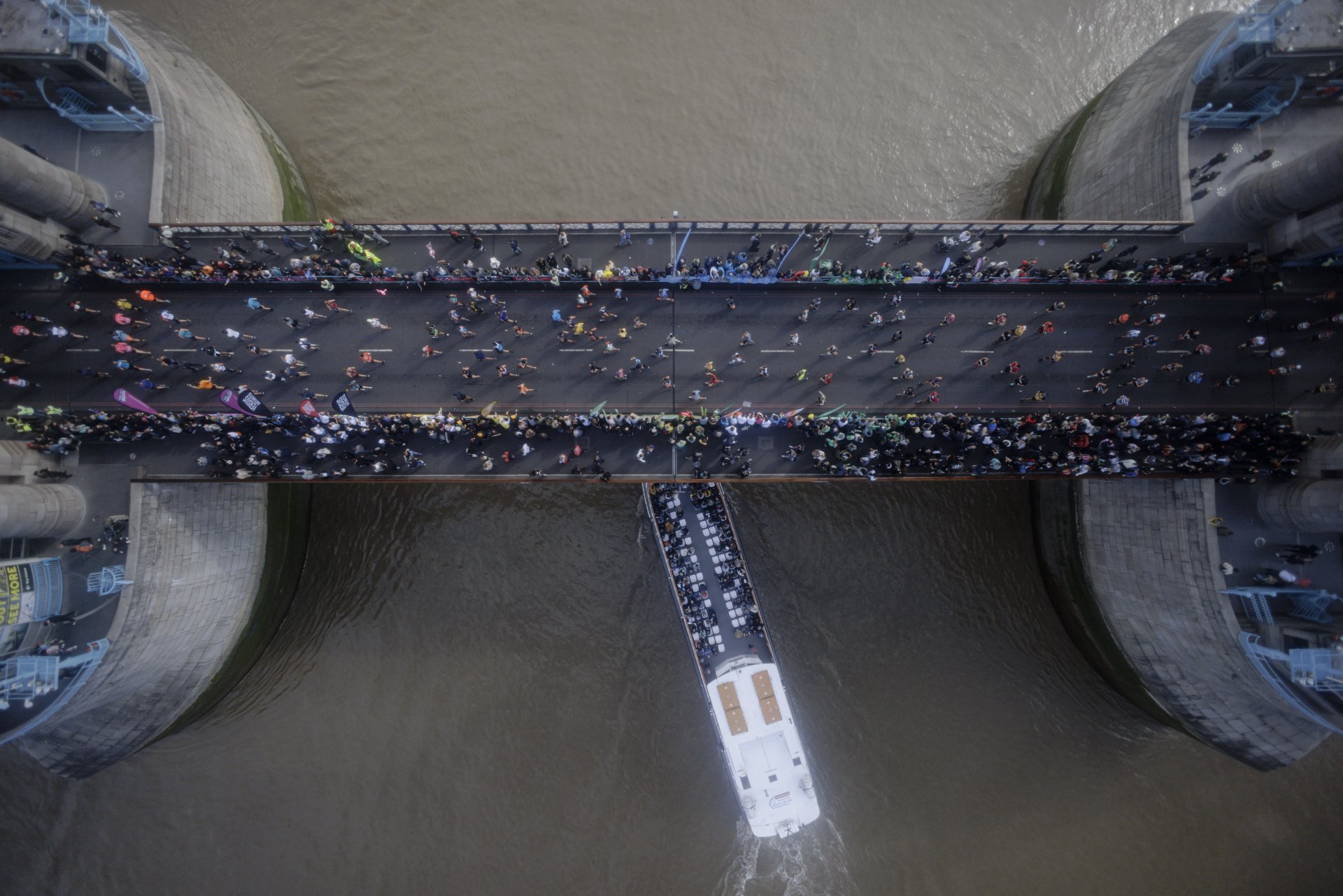  Участници в маратона пресичат Тауър Бридж. Гледката се вижда от високия стъклен под на Тауър Бридж над река Темза. 
