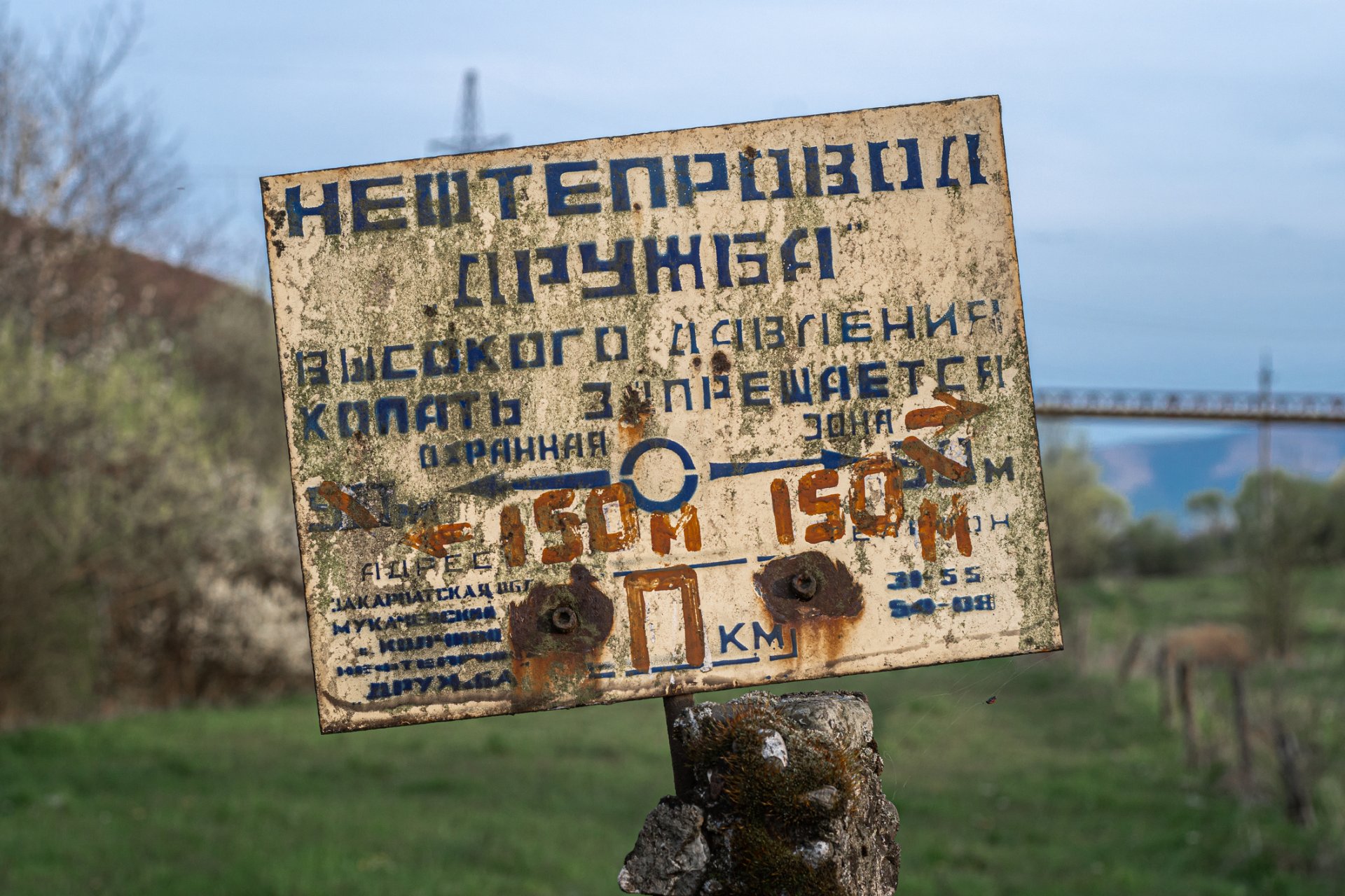 Стара изтъркана табела с надпис "Нефтопровод Дружба" на руски - днес на украинска територия