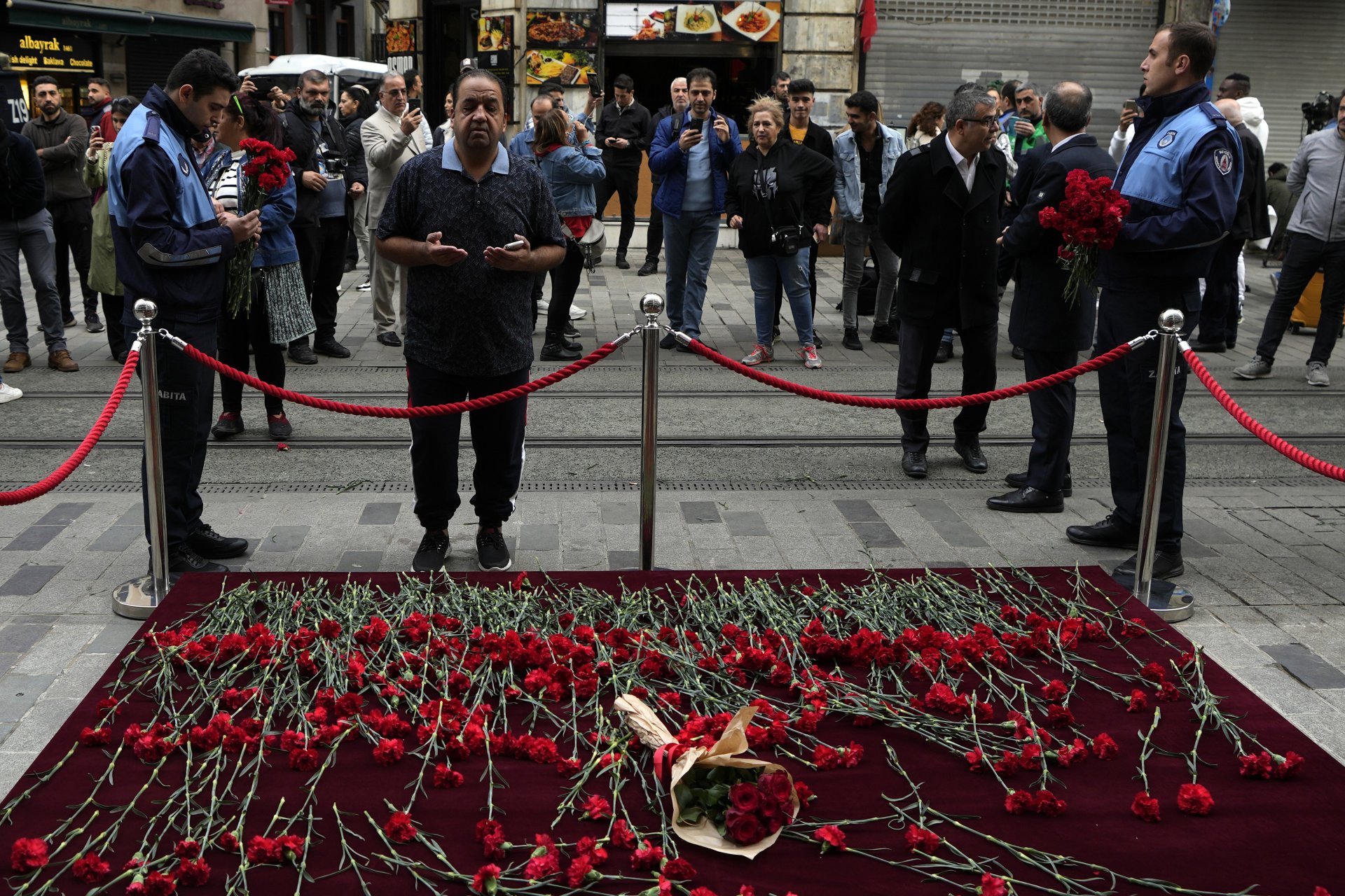 Мъж скърби пред мемориал, поставен на мястото на експлозията в неделя на популярния пешеходен булевард Истиклял в Истанбул