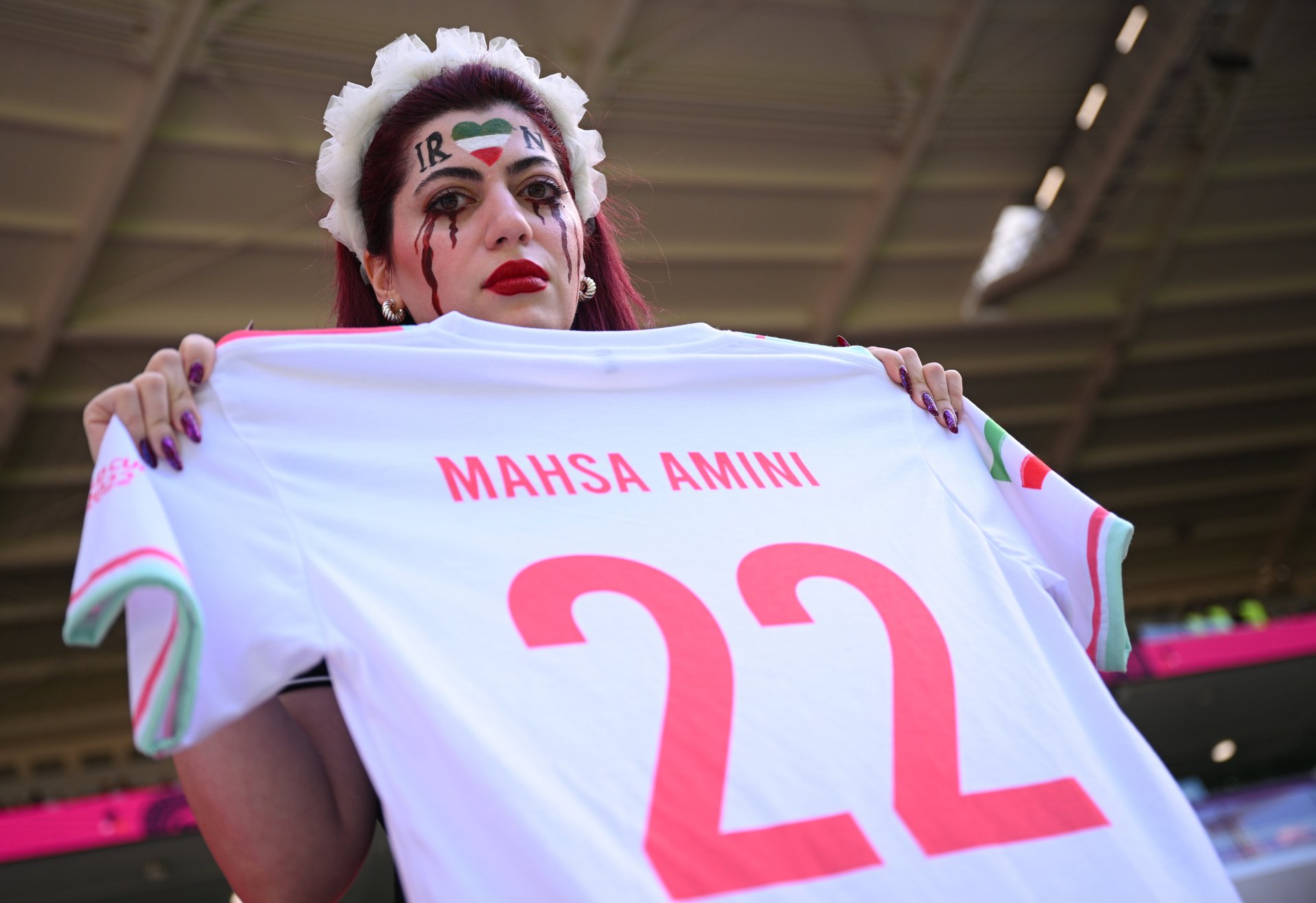 Футболни фенове с фланелка с името на Махса Амини в покрепа на демонстрациите  за правата на жените в Катар