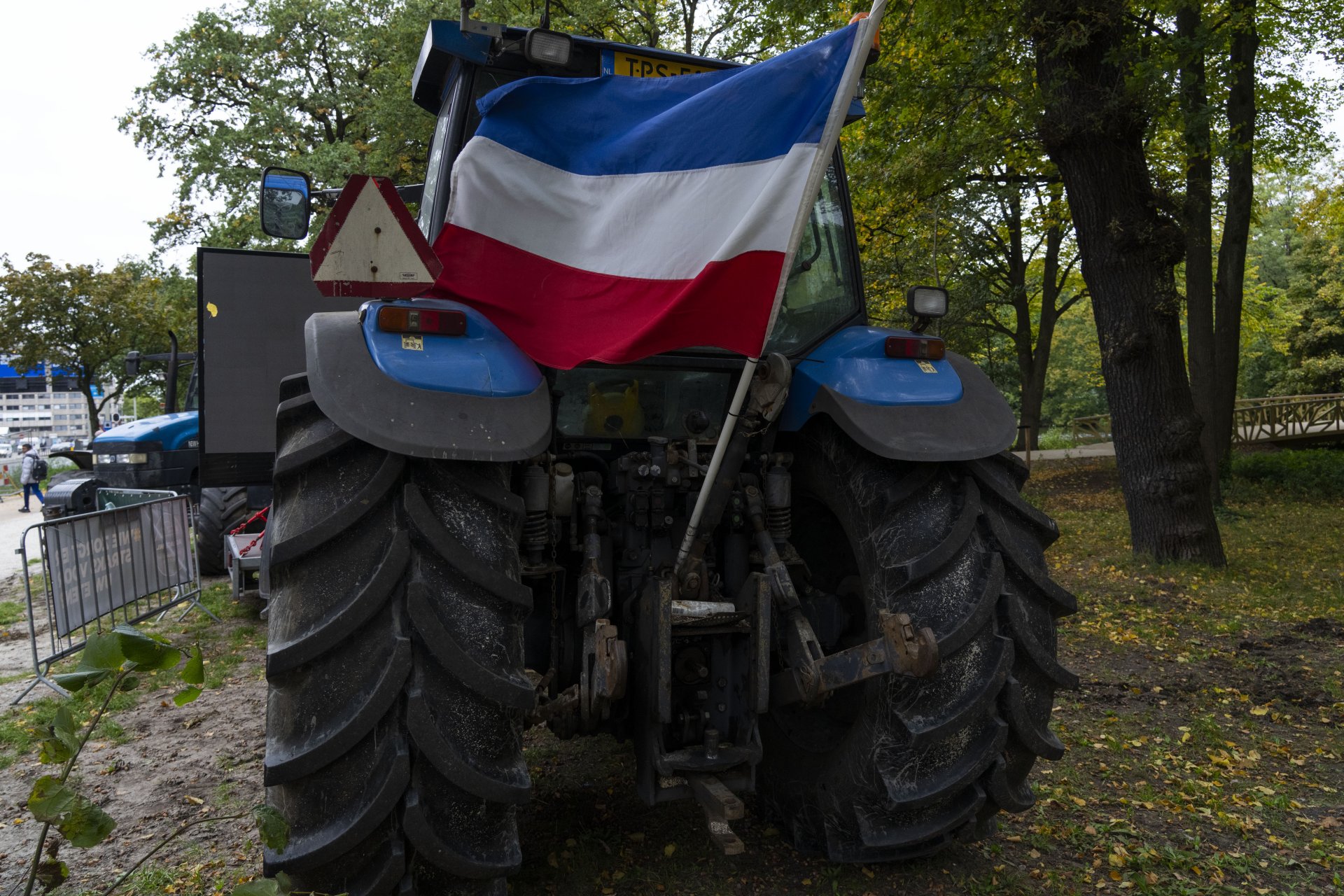Нидерландското знаме се вее наобратно от трактор по време на протест пред парламента в Хага на 5 октомври заради плановете на правителството за драстично намаляване на емисиите от азотни замърсители от селскостопанския сектор