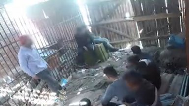 Български полицейски власти държат мигранти в барака с решетки без