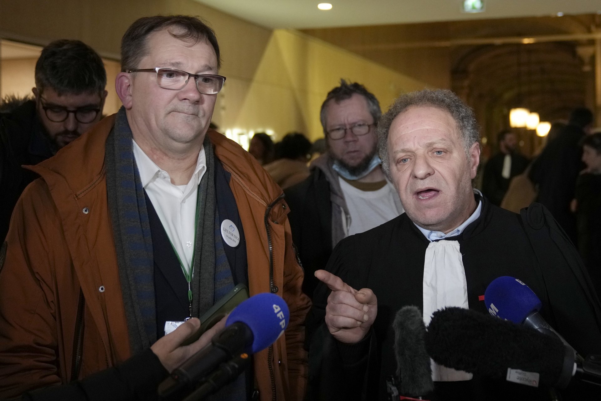 Жан Клод Хюблер, президент на асоциацията на жертвите, вляво, и адвокат Механа Мухоу, вдясно, след края на процеса 