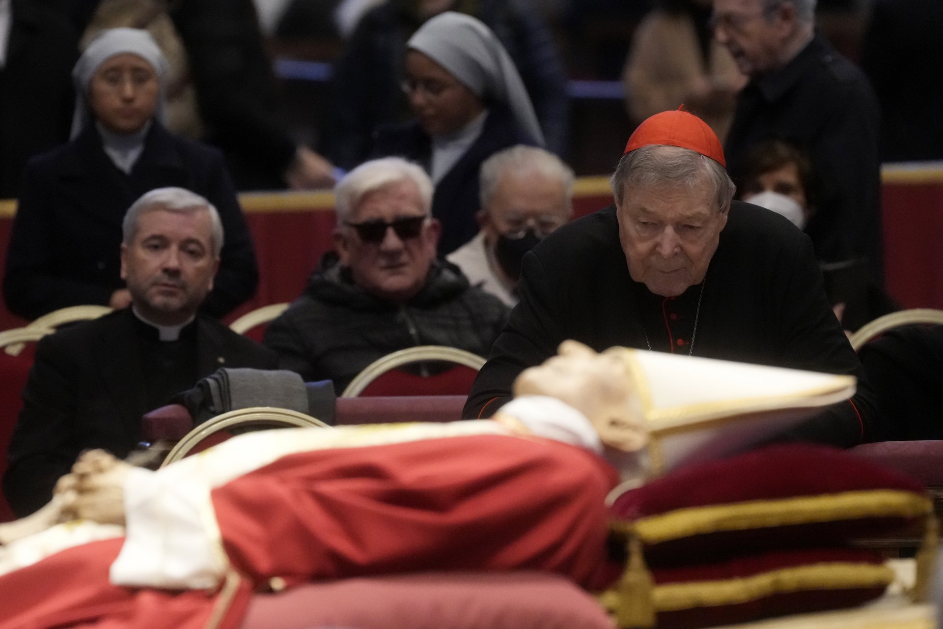 Австралийският кардинал Джордж Пел стои до тялото на покойния папа Бенедикт XVI в базиликата Свети Петър във Ватикана, вторник, 3 януари 2023 г.
