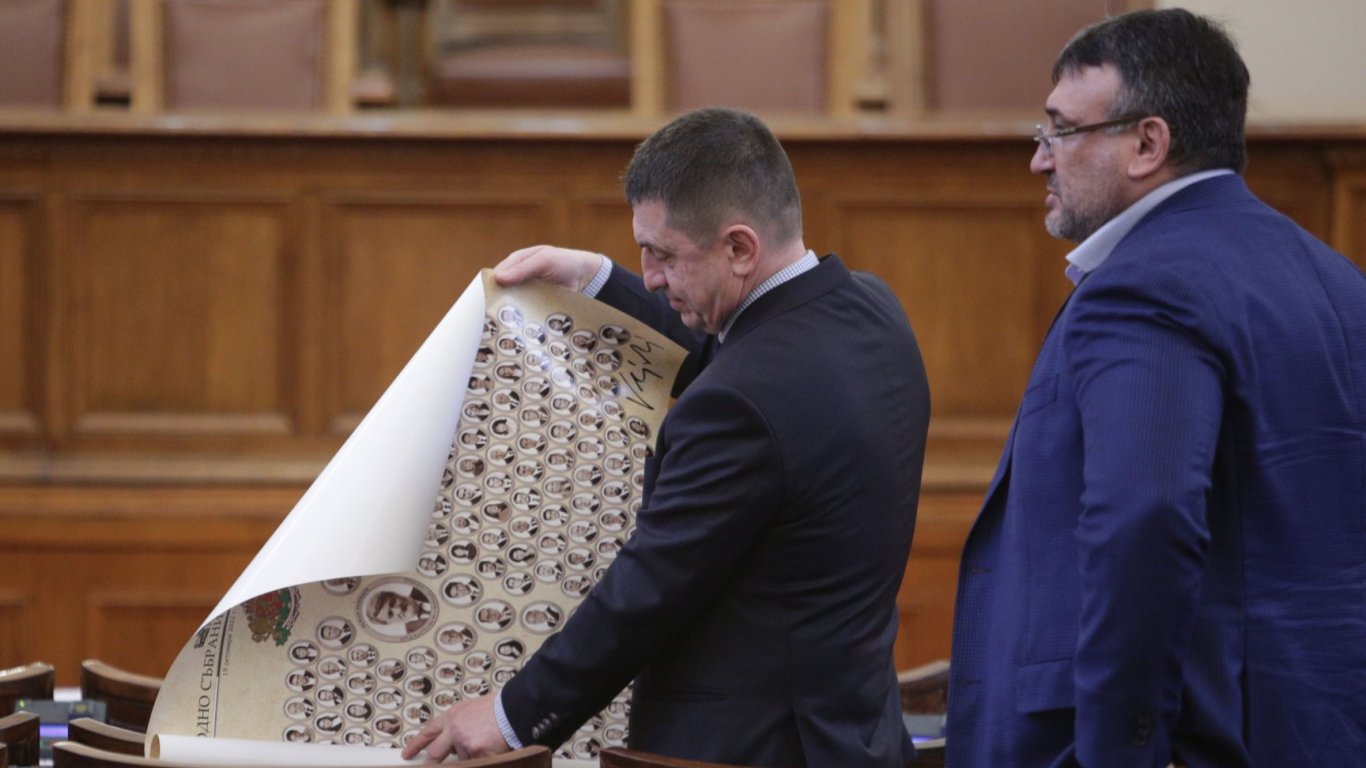Депутати разгъват свитъка със снимките на всички 240 народни представители