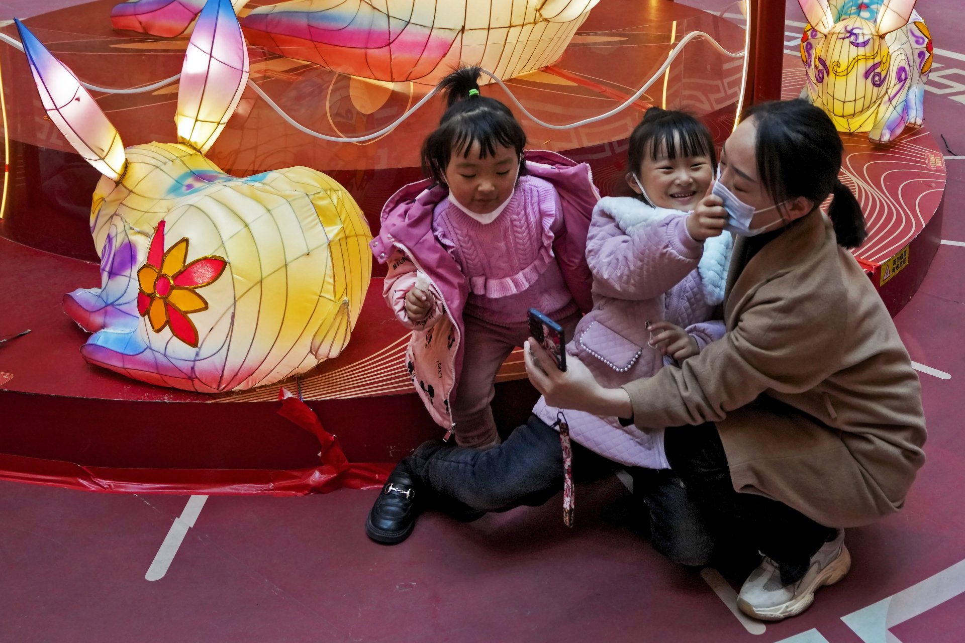 Майка си прави селфи с двете си дъщерички в детски кът на търговски център в Пекин на 5 февруари