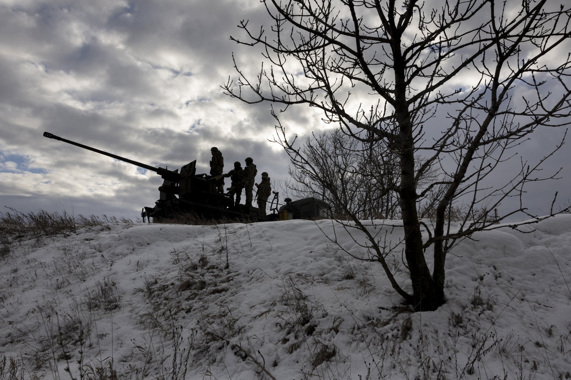 Украински войници гледат към руските позиции, докато са на върха на противовъздушно оръдие на 14 февруари 2023 г. близо до Бахмут, Украйна.