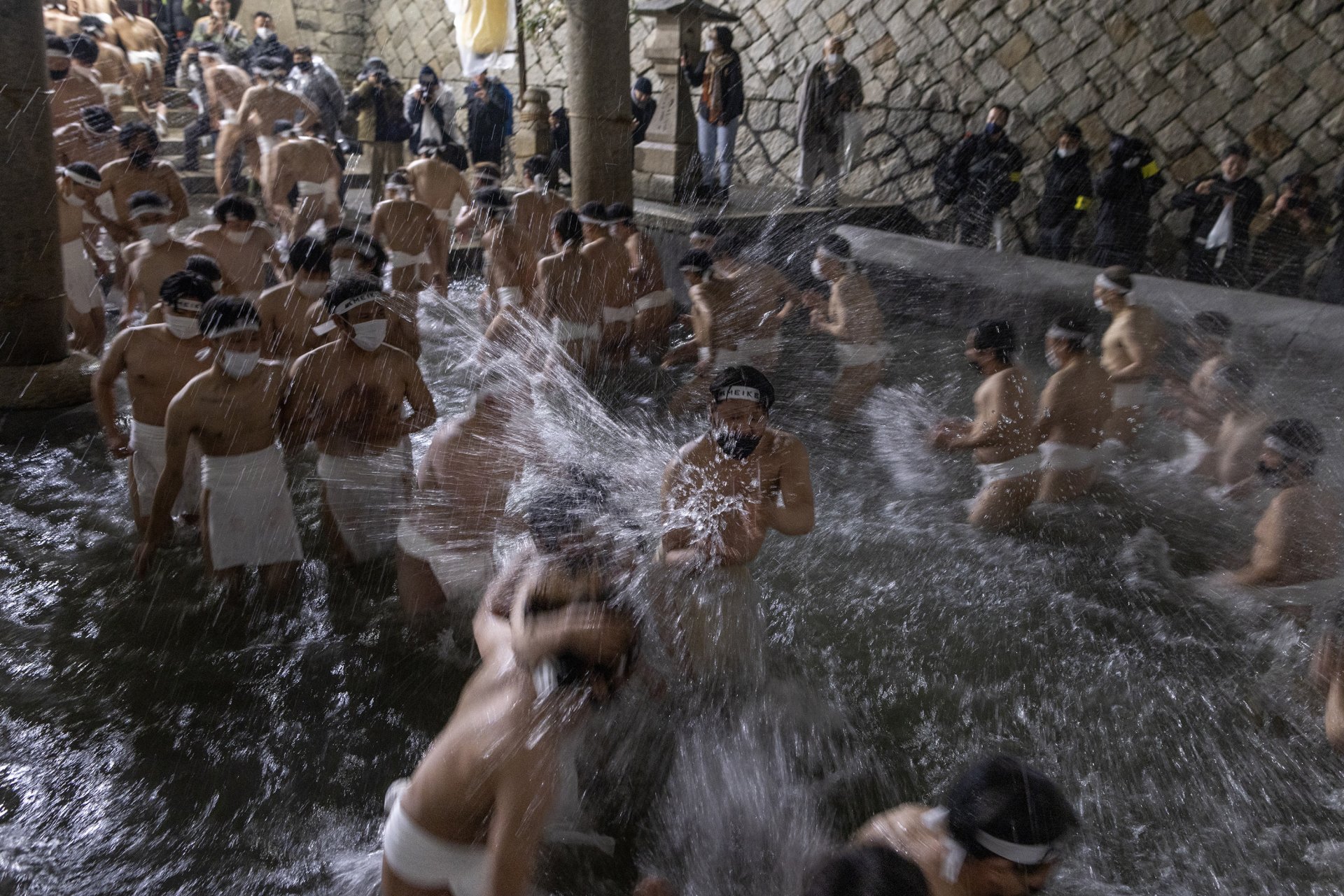  Участници пречистват телата си във фонтан, преди да влязат в храма за Голия фестивал, или Хадака Мацури в храма Сайдаджи на 18 февруари 2023 г. в Окаяма, Япония. 