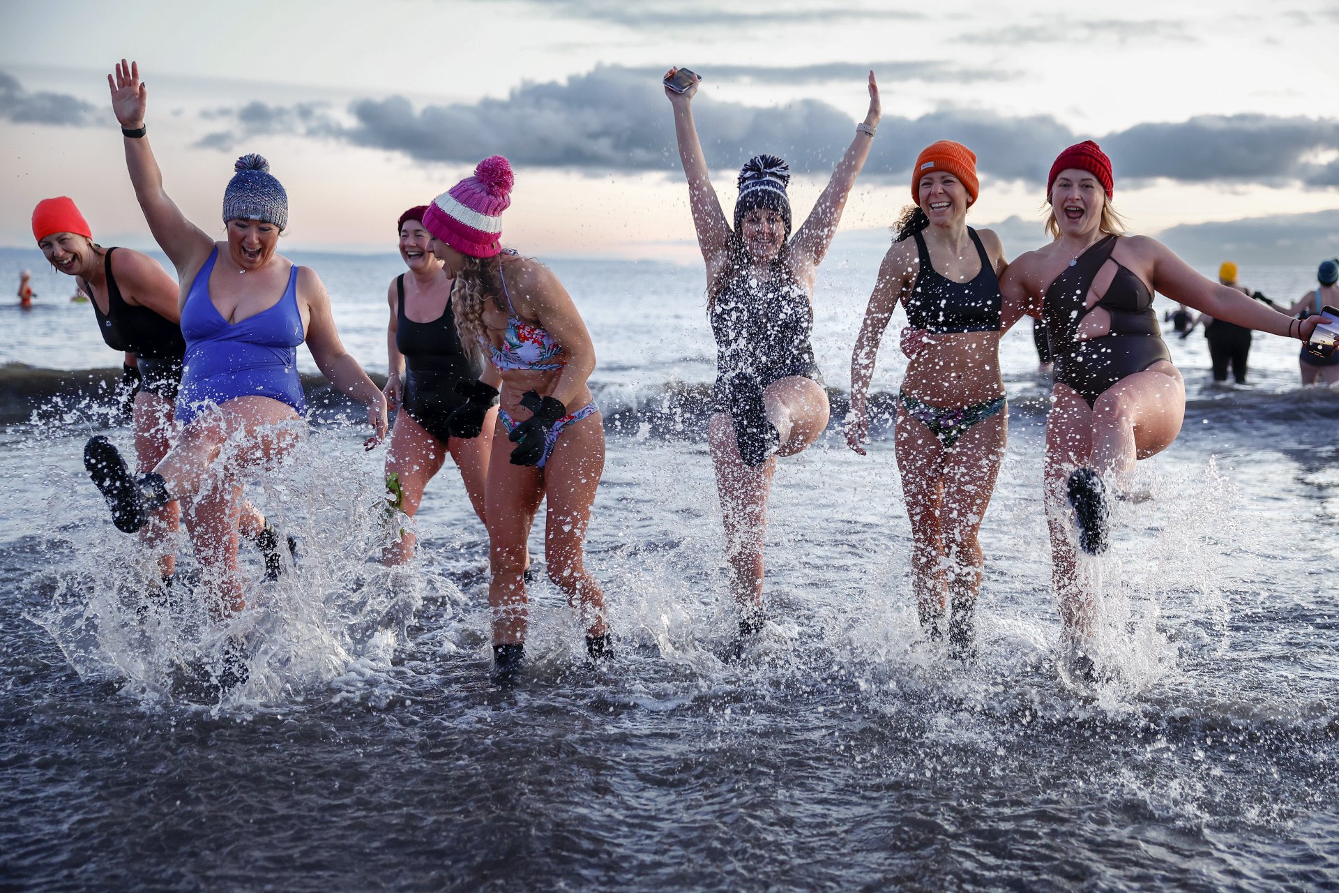 Стотици плувци се потопиха при изгрев слънце в Северно море на плажа Портобело за Международния ден на жената на 8 март 2023 г. в Единбург, Шотландия.
