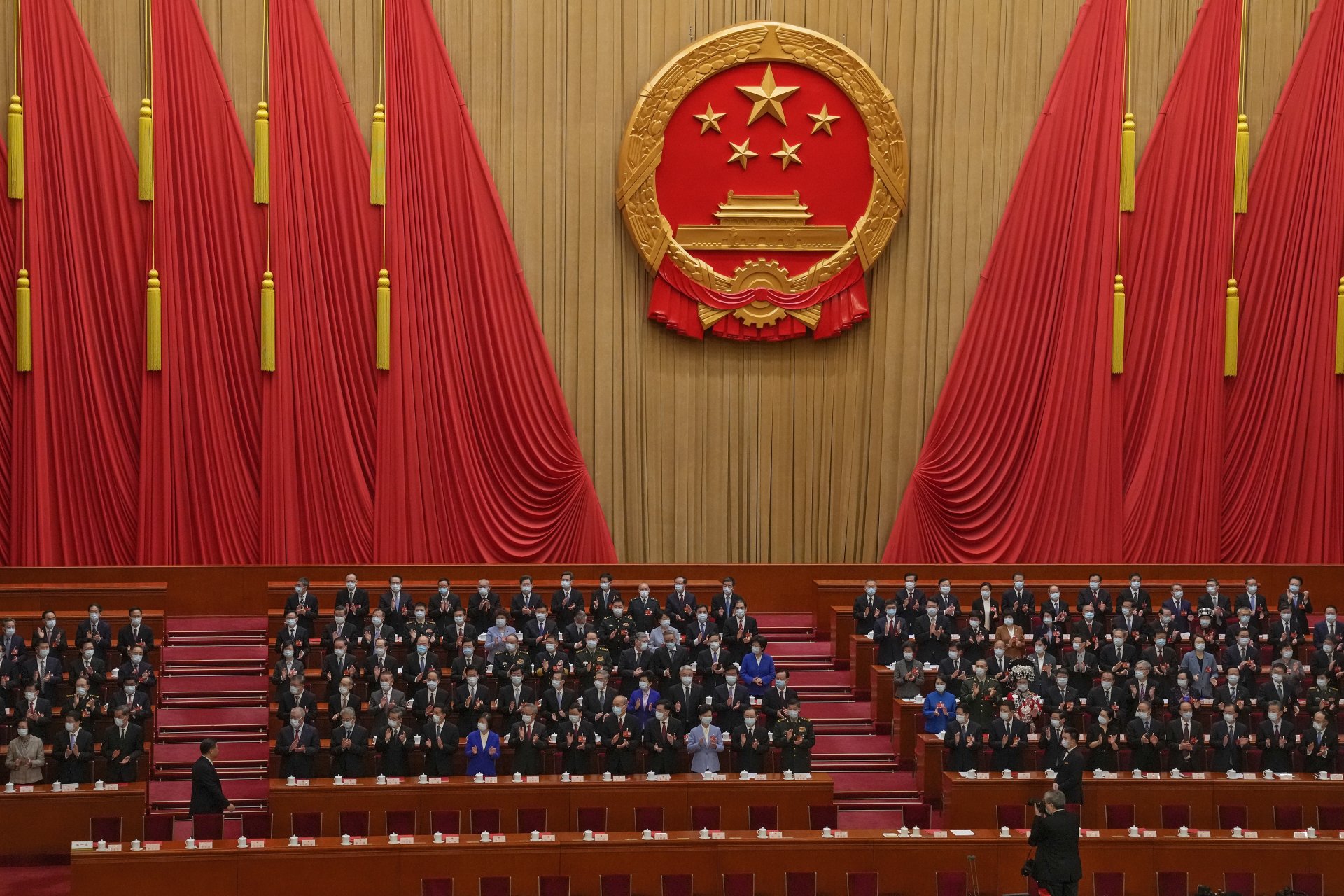 Делегатите аплодират, докато китайският президент Си Дзинпин, вляво, пристига на церемонията по закриването на Общокитайското събрание на народните представители 