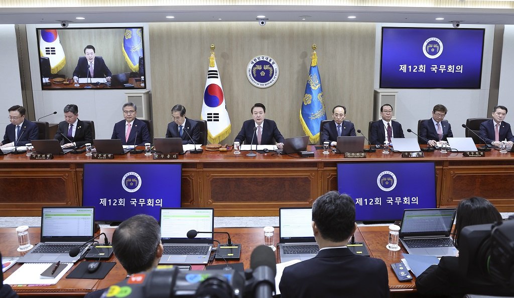 Южнокорейският президент Юн Сук Йол, горе в средата, говори по време на заседание на кабинета в кабинета на президента в Сеул, Южна Корея, вторник, 21 март 2023 г.